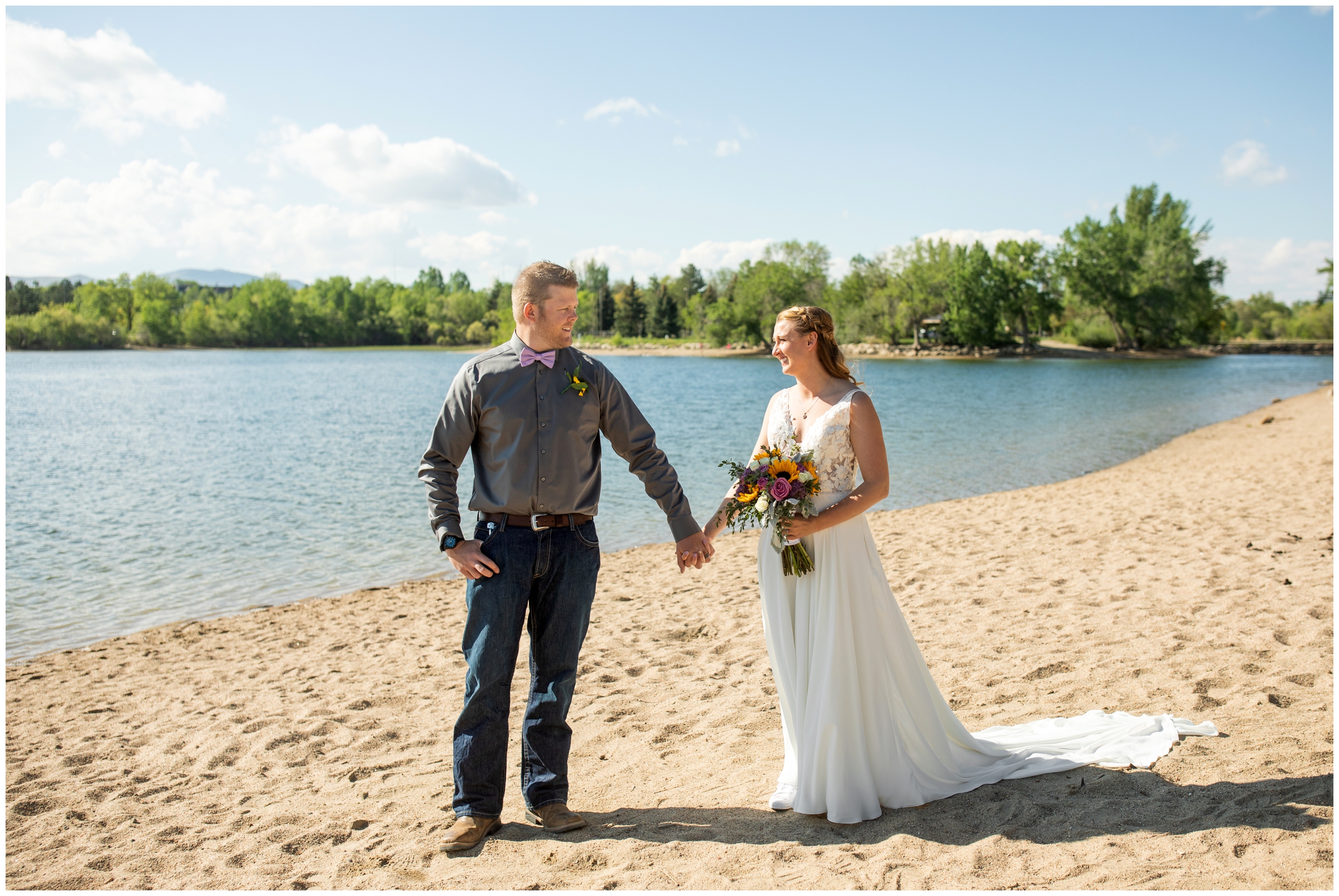 couple holding hands on the sandy beach next to Lake Loveland during spring wedding pictures in Colorado 