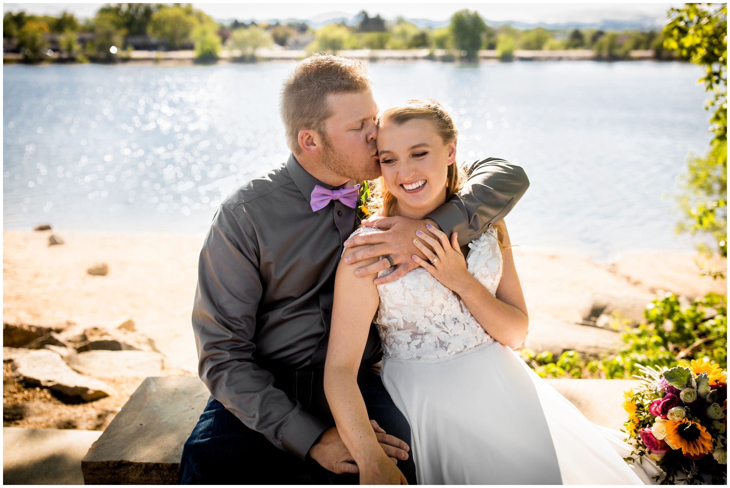 couple cuddling next to Lake Loveland during spring wedding pictures in Northern Colorado 