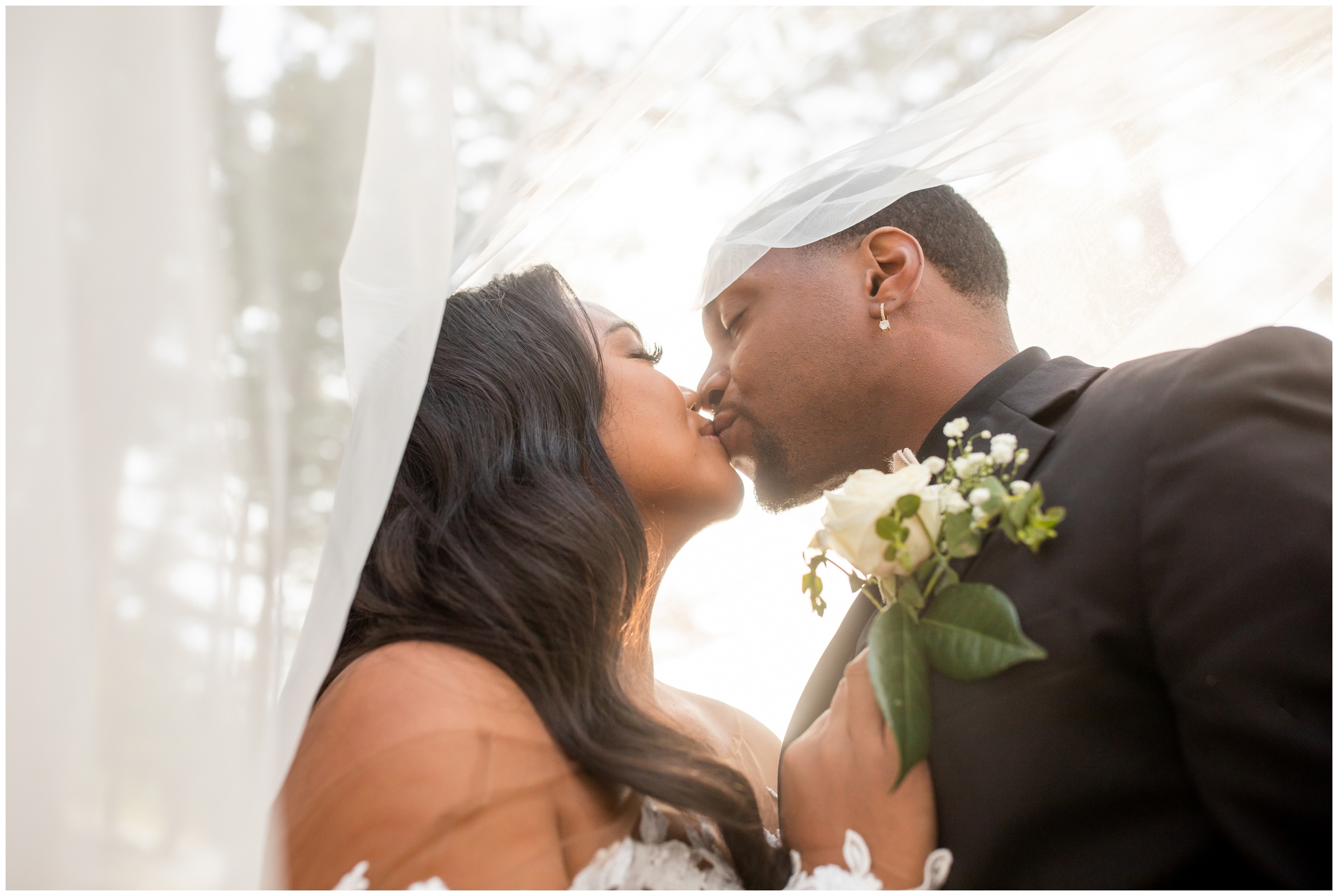 couple kissing underneath veil during Colorado spring wedding portraits at the Pines at Genesee