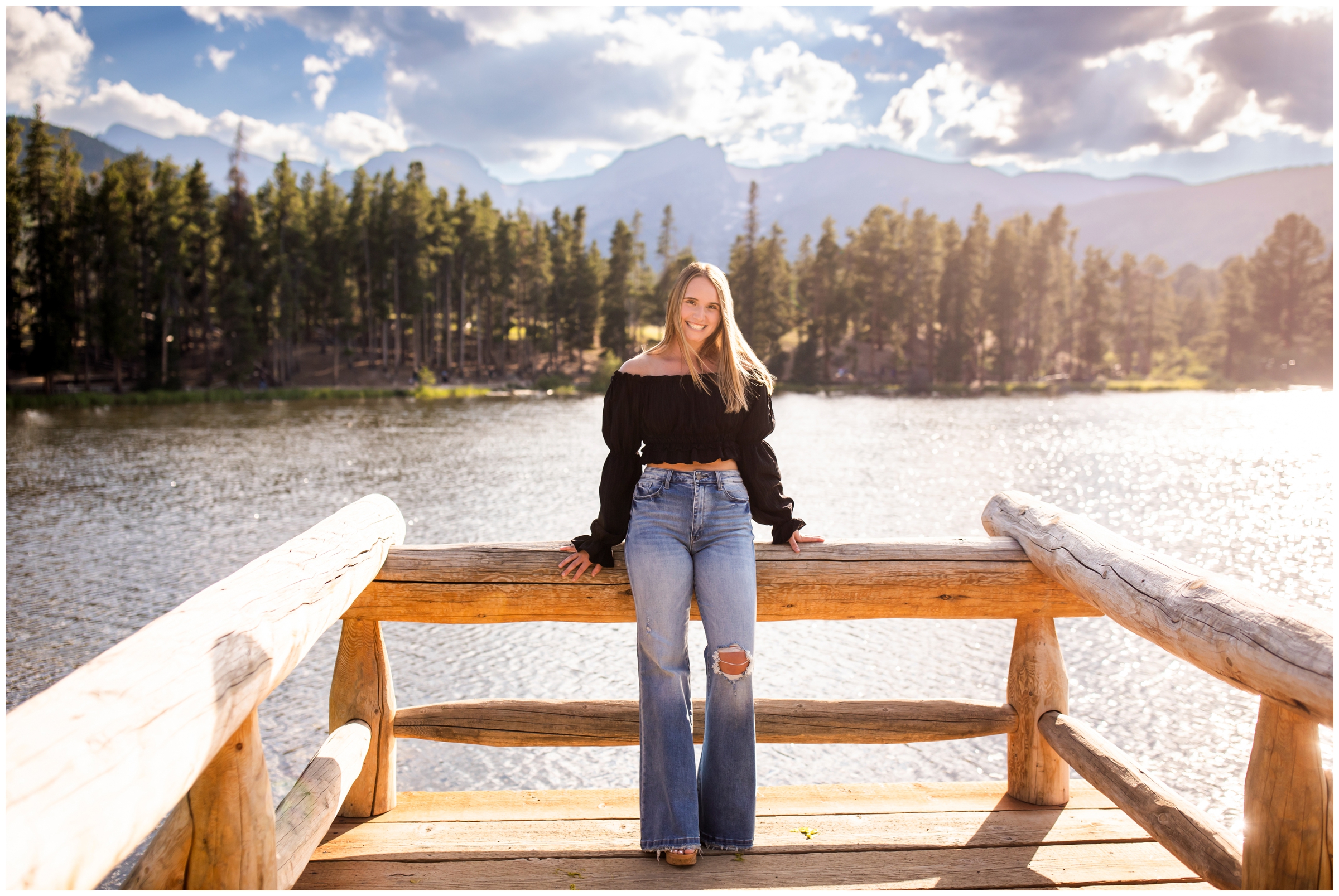 teen girl leaning against dock of Sprague Lake during mountain senior pictures in Estes Park Colorado