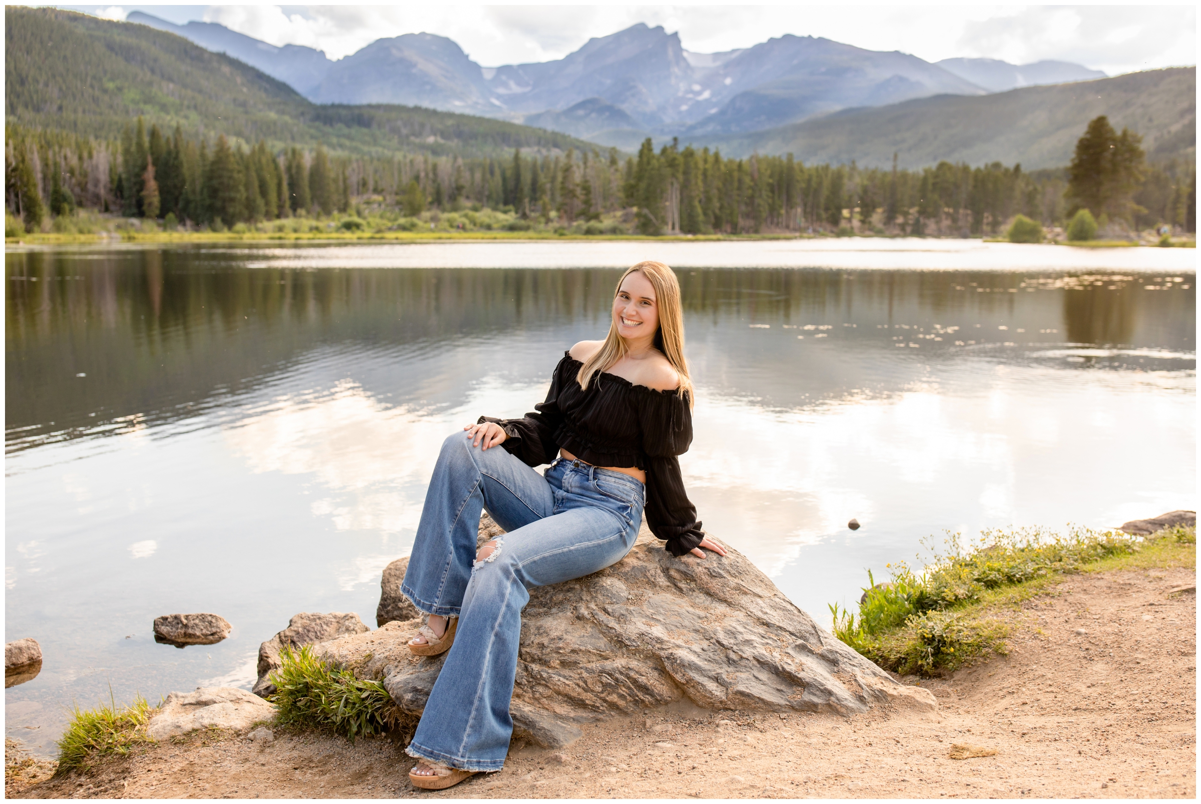 teen girl sitting on a rock with mountains in background during Colorado senior portraits in RMNP Estes Park