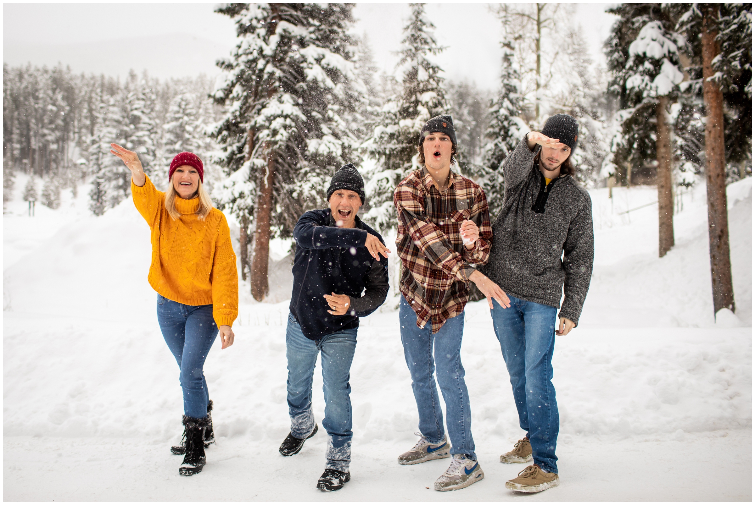 family throwing snowballs at the camera during candid winter family photos in the Colorado mountains 