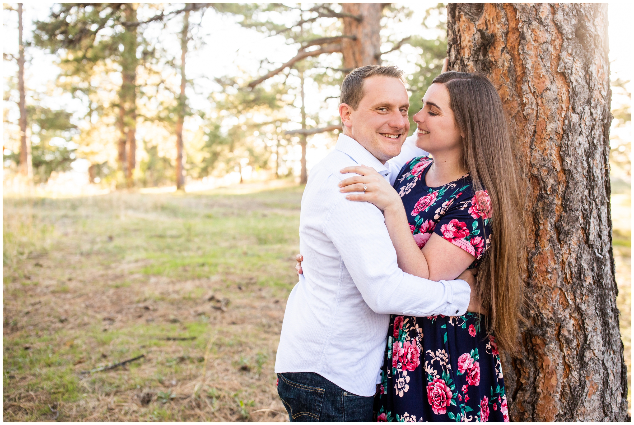couple leaning against a tree during spring engagement portraits in the Colorado mountains at Mount Falcon West 