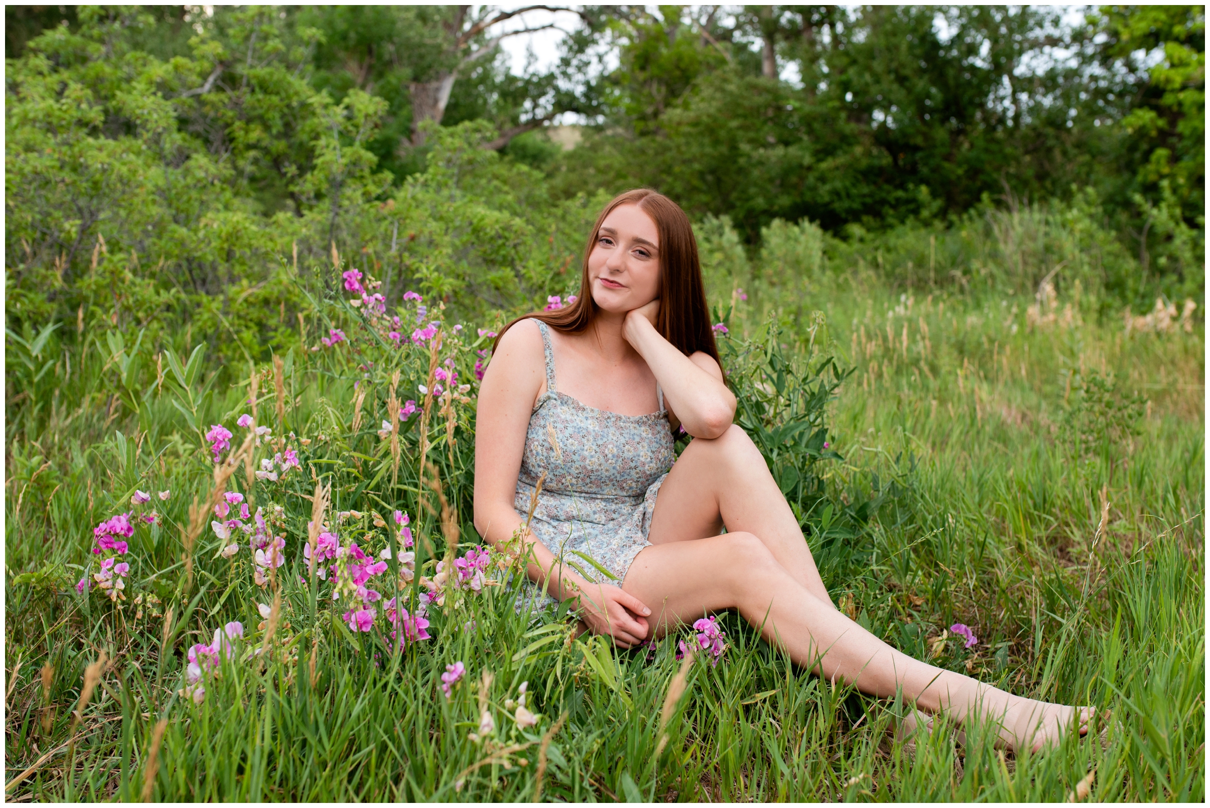 teen sitting in wildflowers during Colorado mountain senior pictures in Boulder 