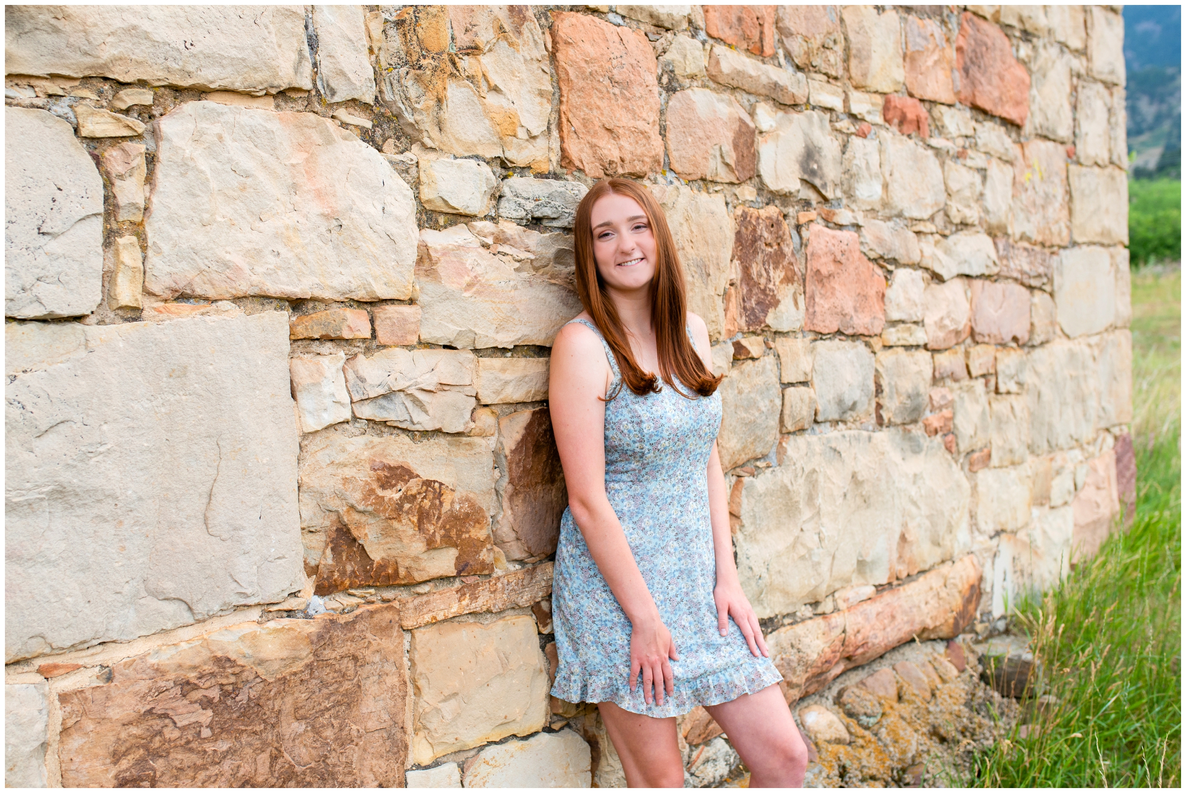 teen girl leaning against stone wall at South Mesa Trail during Boulder Colorado senior photos 