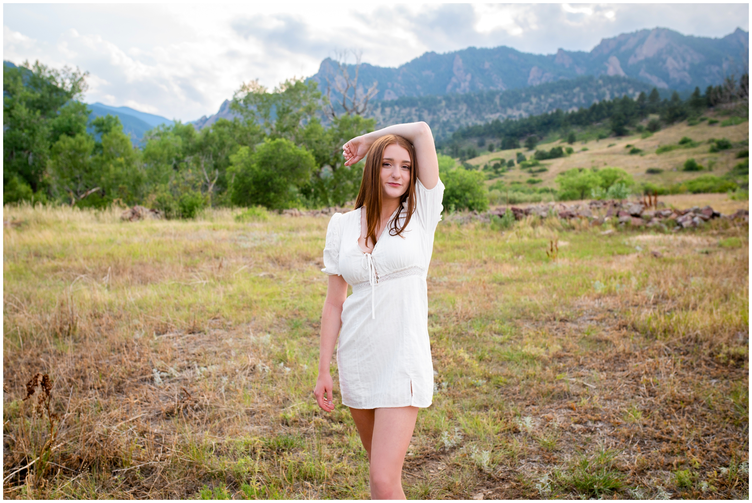teen posing with flatirons mountains in background during Boulder Colorado senior portraits