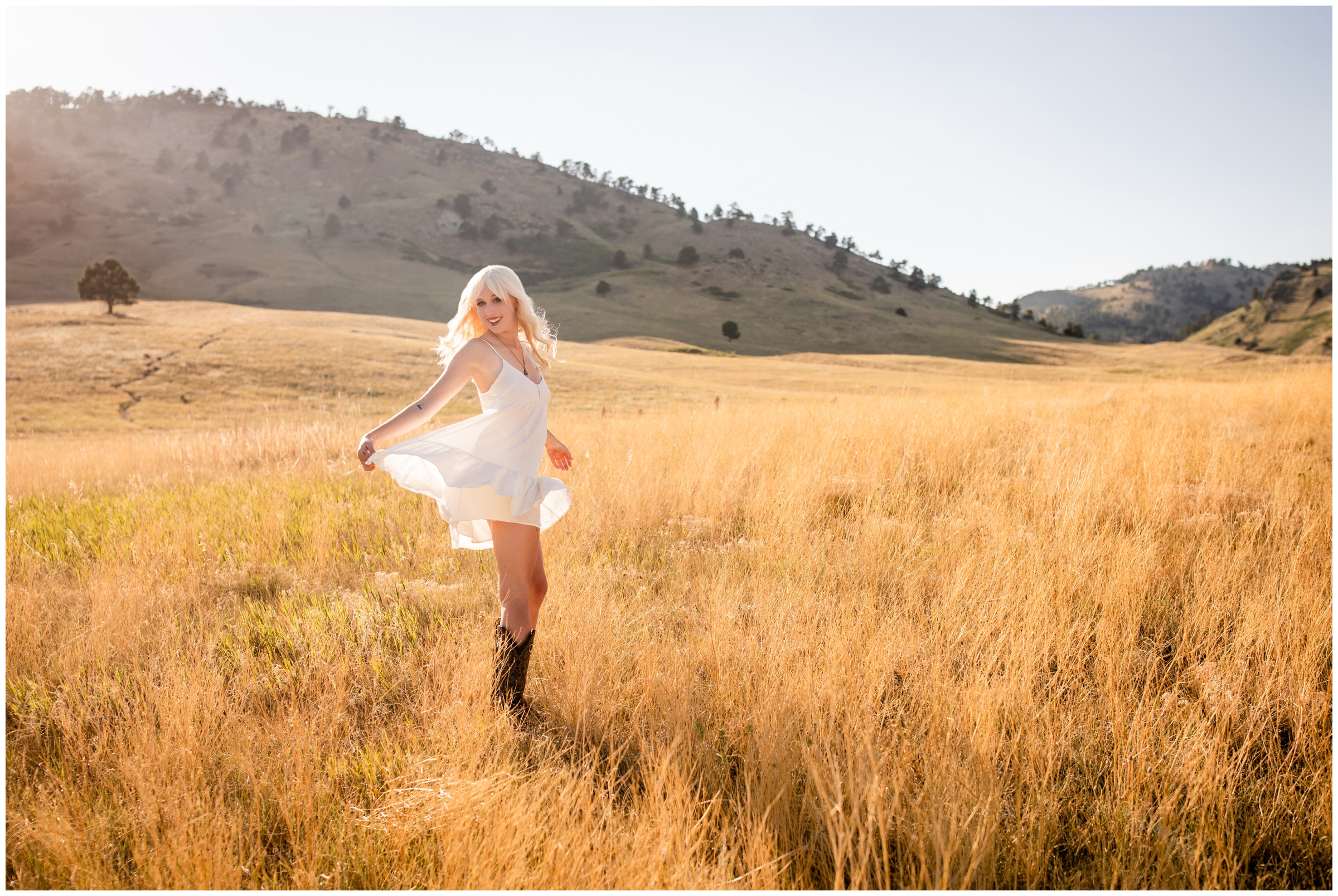teen twirling in an open field of golden grasses during Boulder Colorado senior portrait photography session