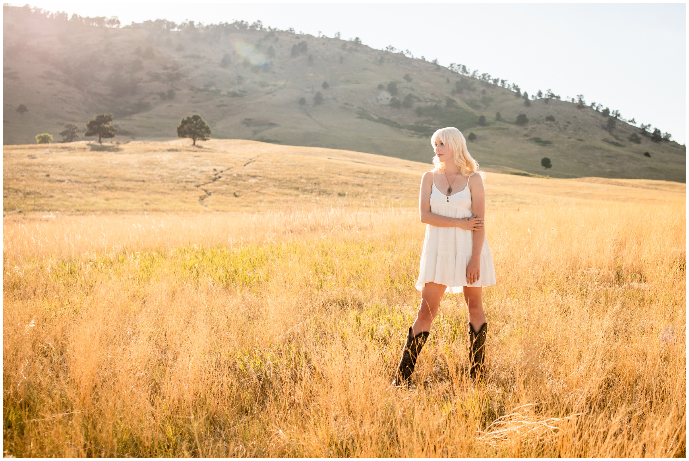 teen posing in field of golden grasses during Colorado graduation pictures 