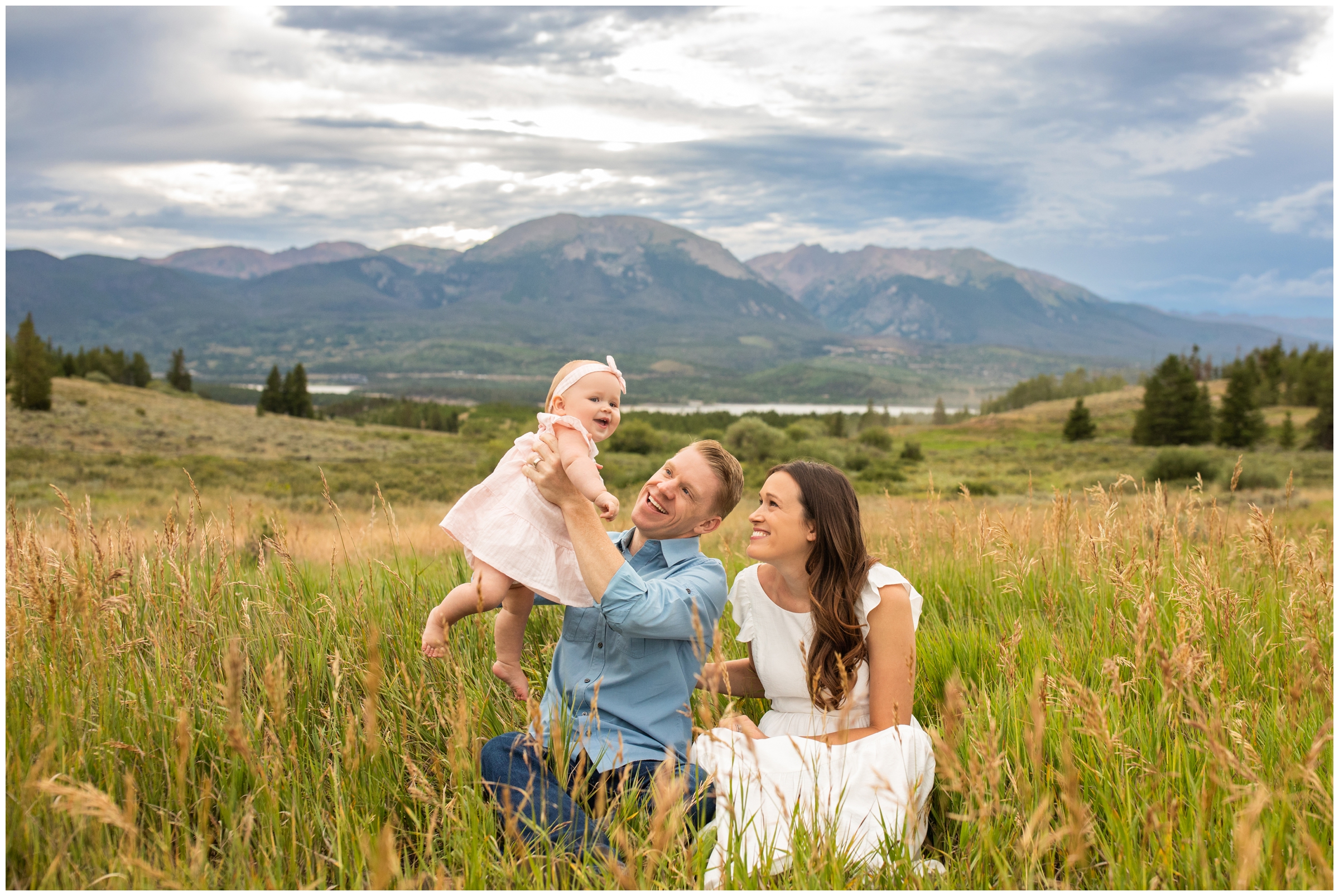 family sitting in open field during candid Breckenridge Colorado family pictures at Windy Point campground