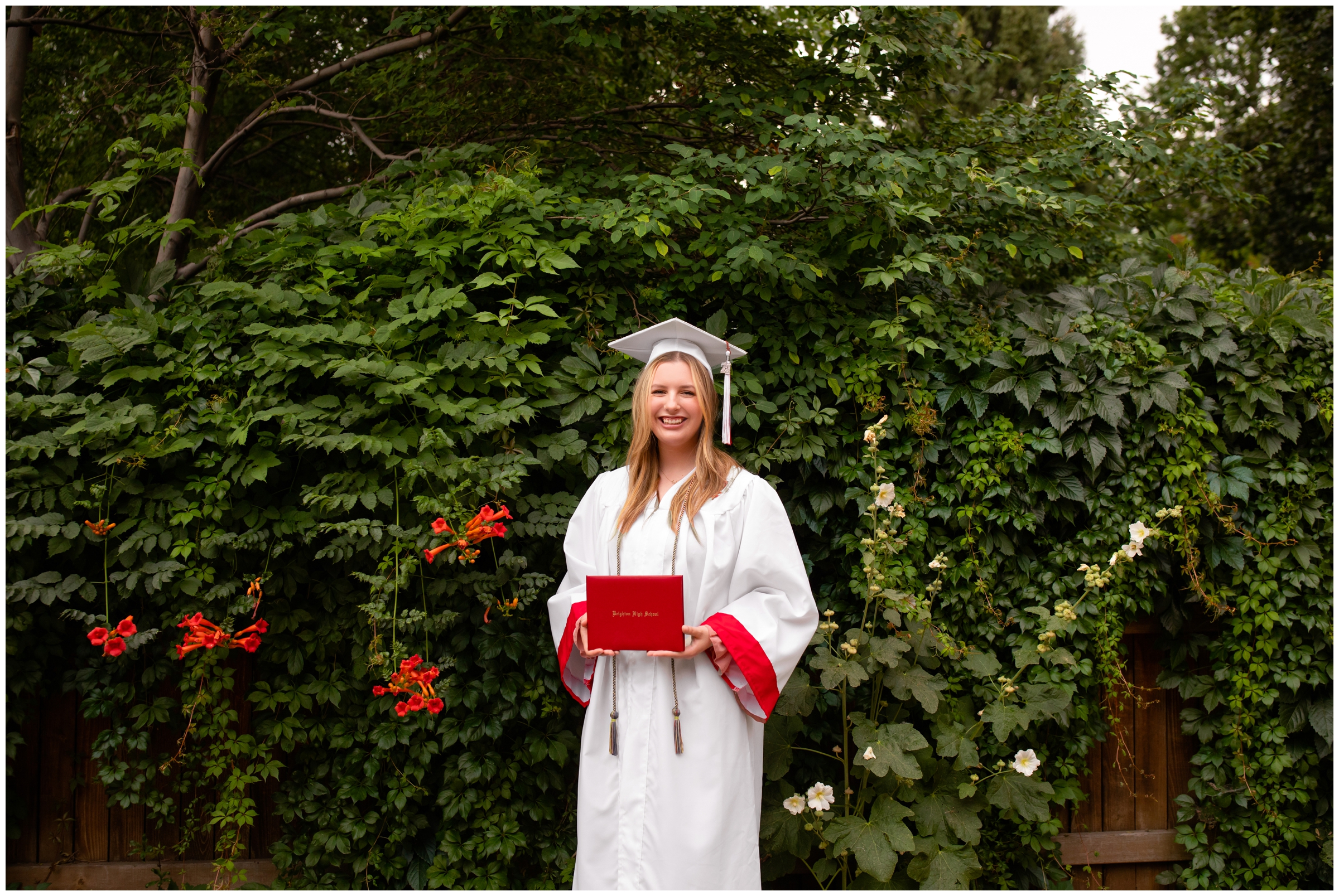 teen posing with her diploma during high school graduation portraits at Callahan House in Longmont Colorado