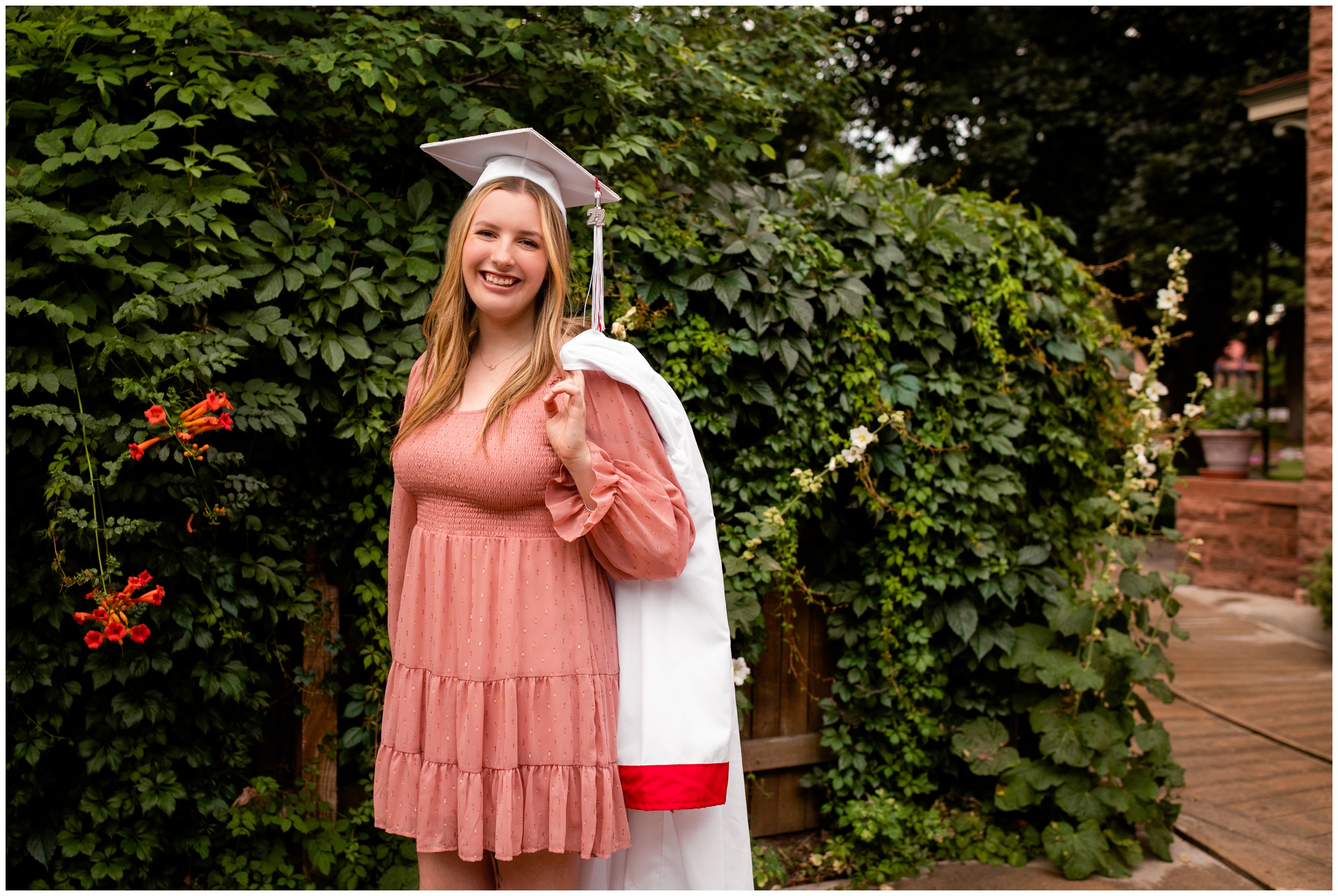 teen girl posing with graduation cap and gown during Longmont Colorado senior pictures 