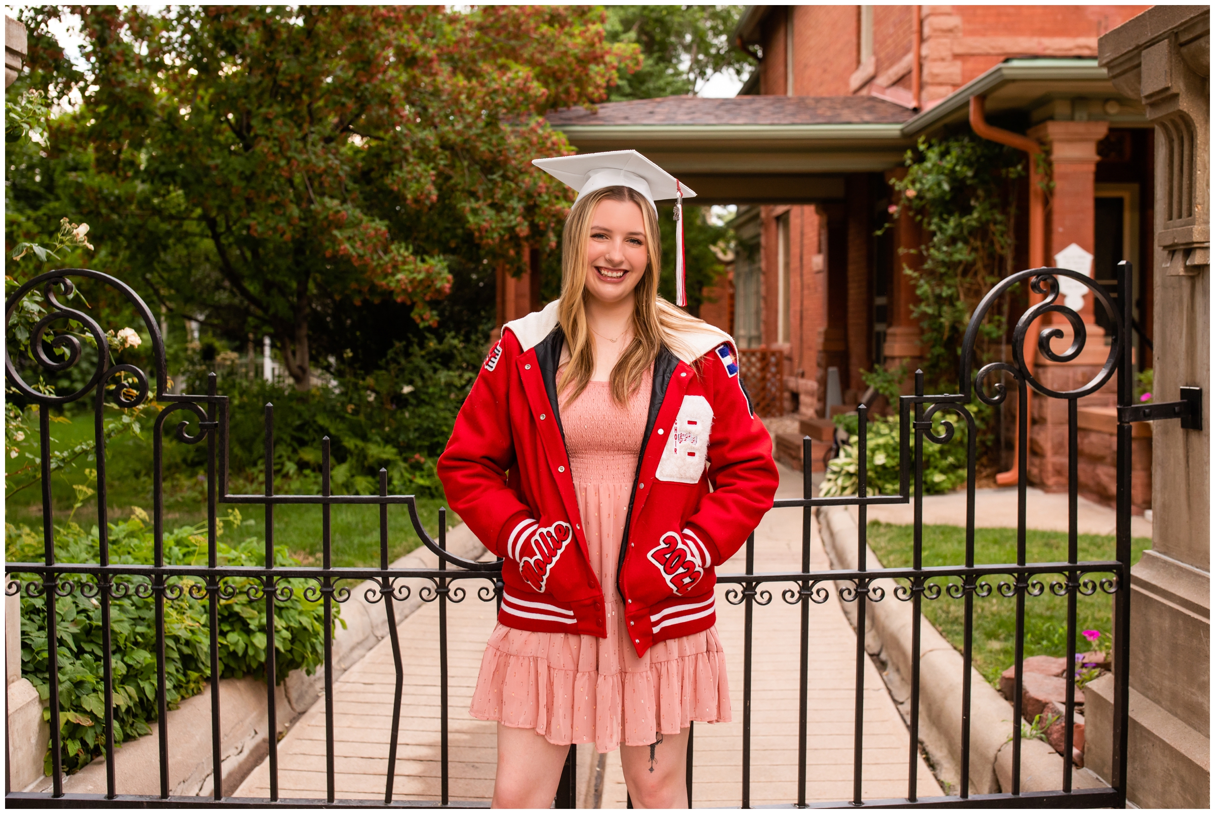 teen posing in letterman jacket and graduation cap during Colorado cap and gown photo session in Longmont 