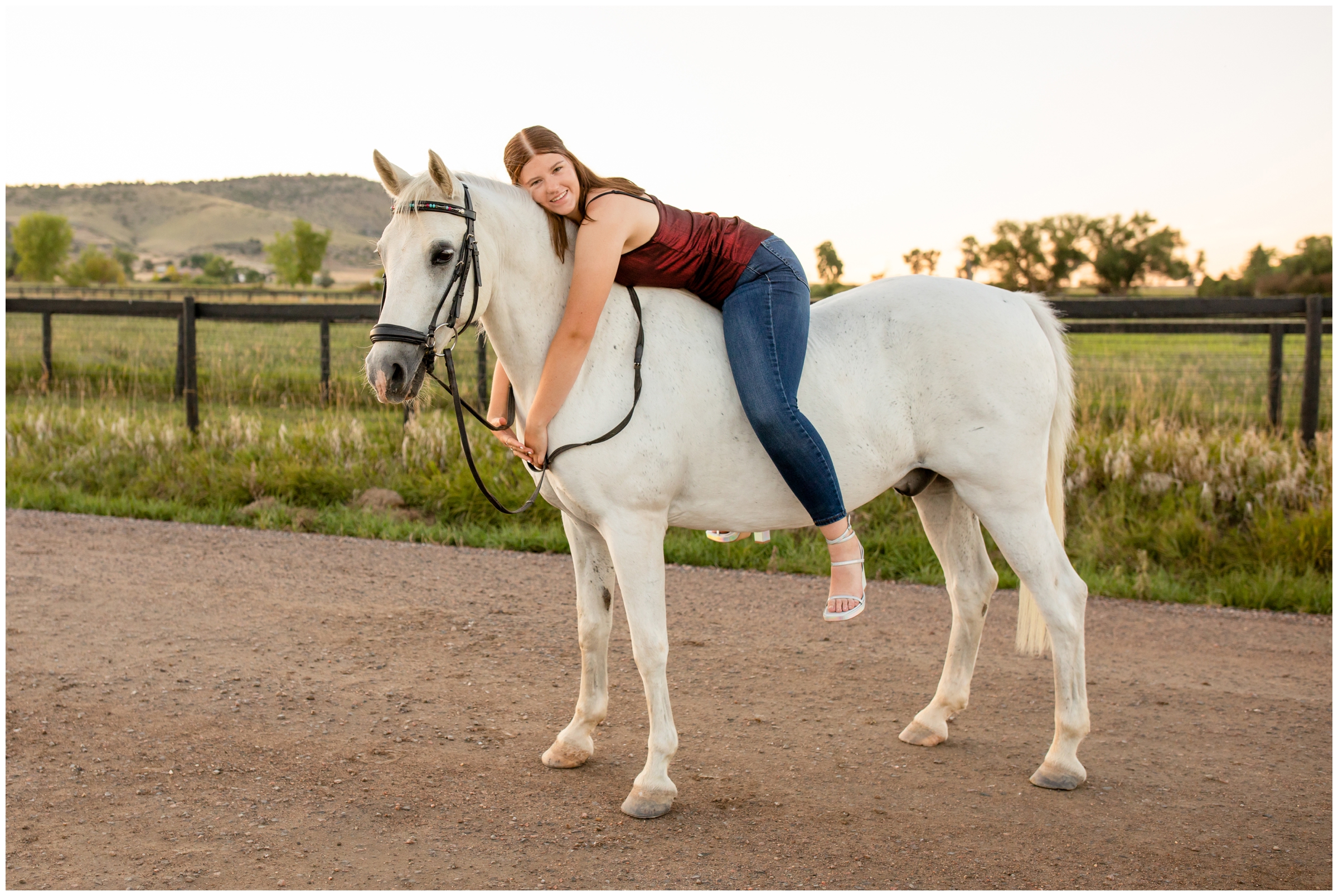 teen laying on horses back during Colorado horse senior portraits by Longmont CO photographer Plum Pretty Photography