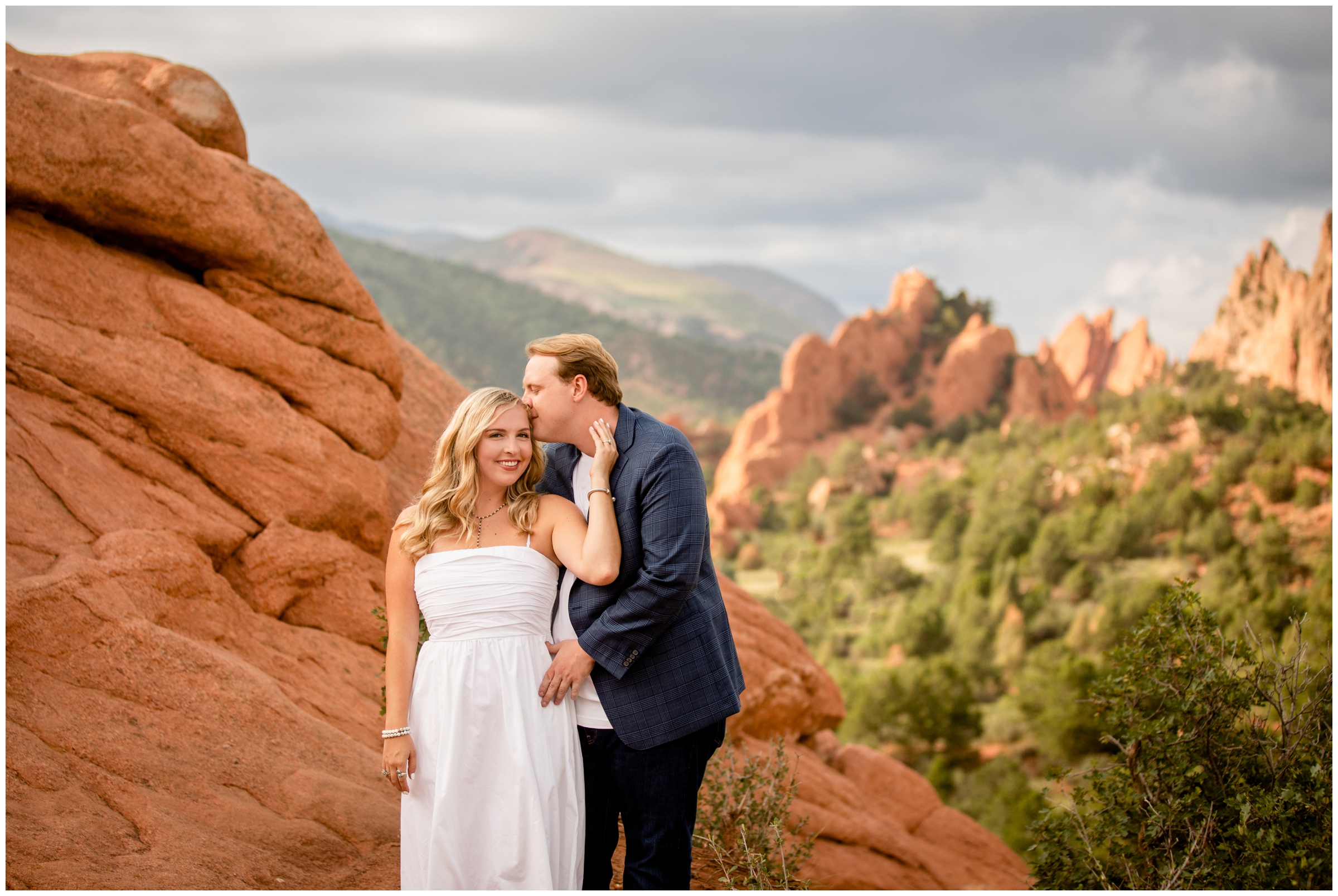 couple kissing at High Point overlook during summer engagement portraits at Garden of the Gods in Colorado Springs
