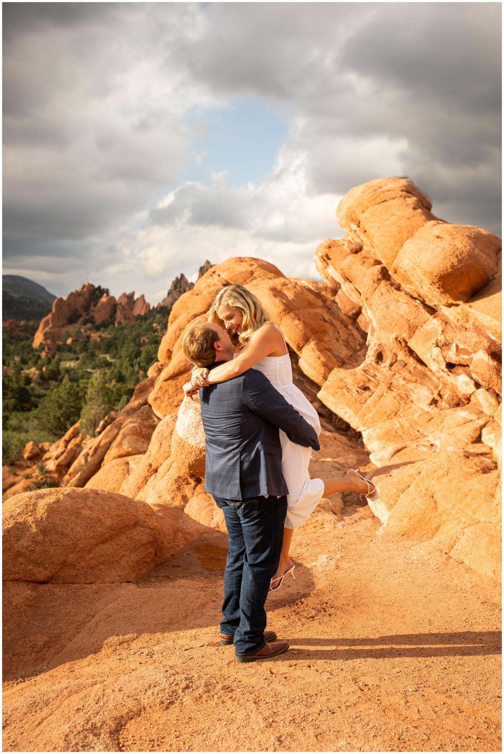guy lifting his fiancé during Garden of the Gods Colorado Springs engagement pictures 