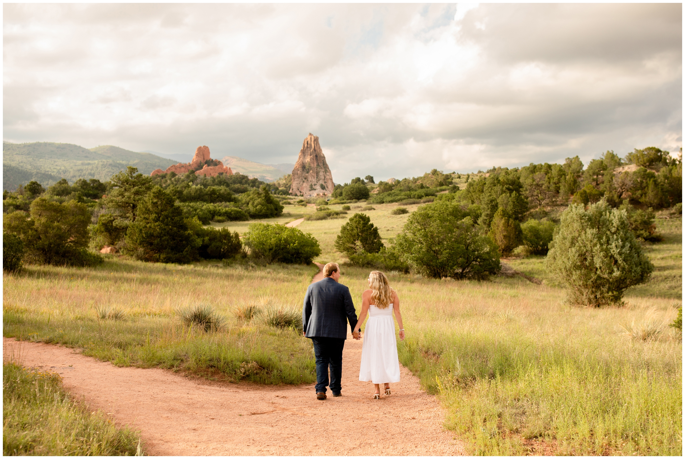 couple walking down dirt path during engagement photography session in Colorado Springs