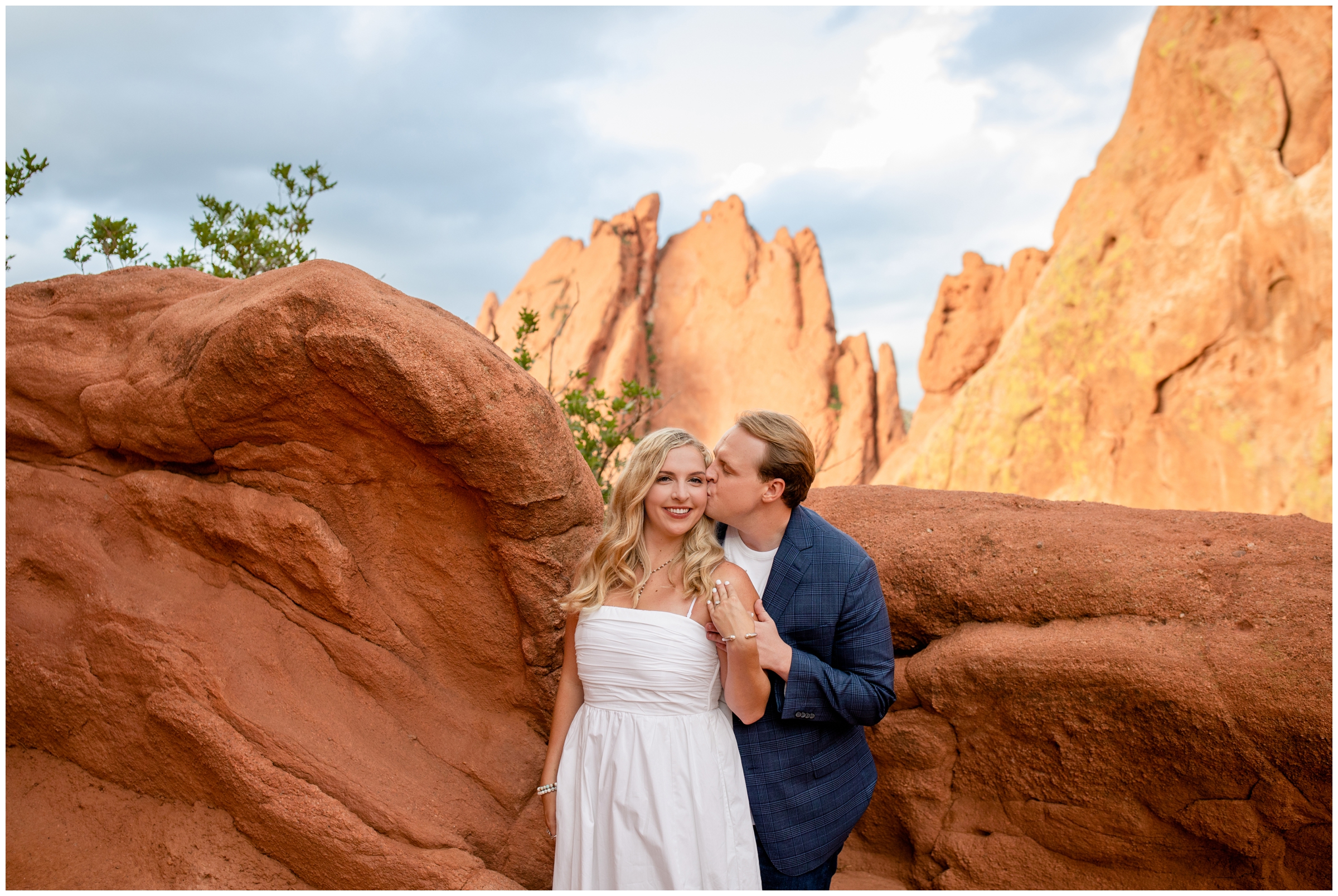 couple embracing with red rock formations in background during Colorado Springs engagement pictures at Garden of the Gods