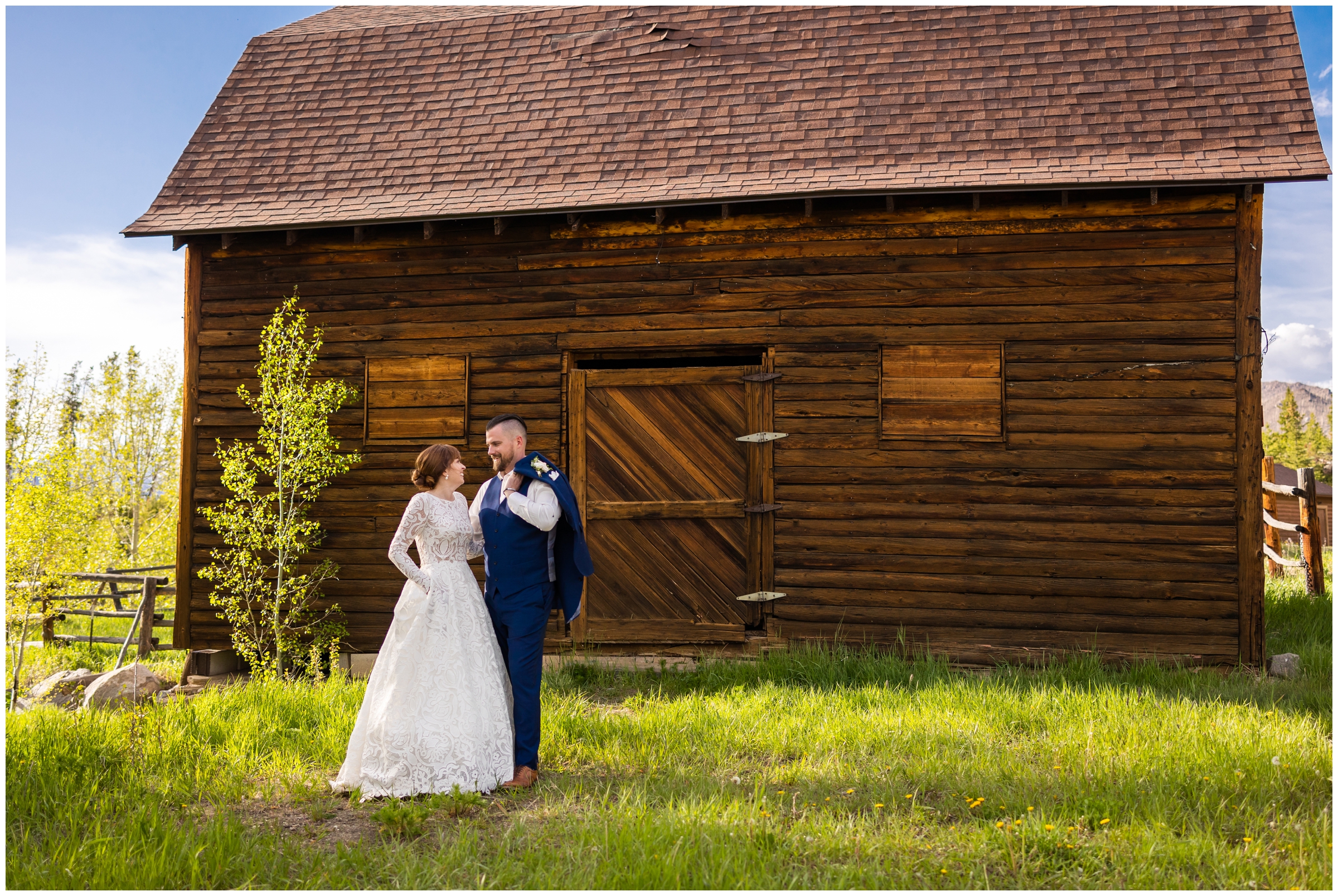 couple posing in front of wooden barn during rustic wedding pictures at the Grand Lake Lodge 