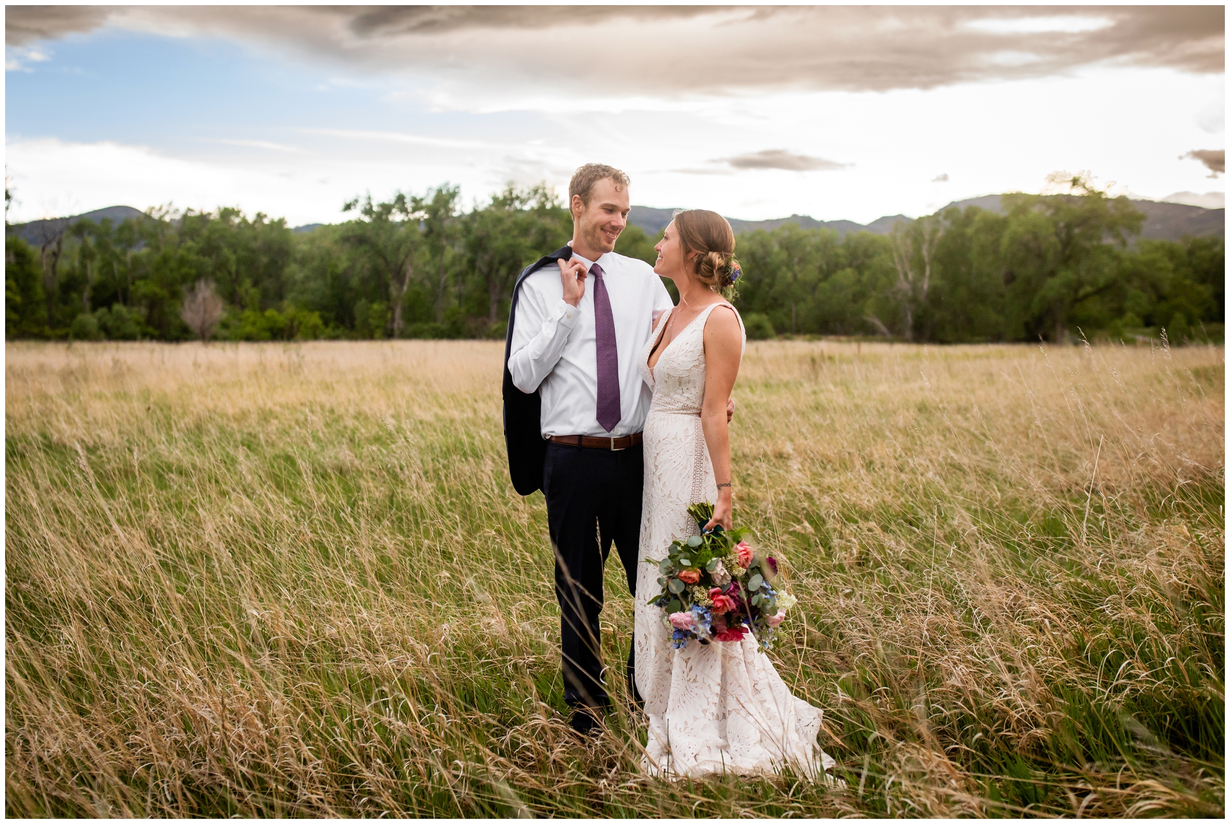 couple posing in a field at sunset during rustic Fort Collins wedding at Rist Canyon Inn