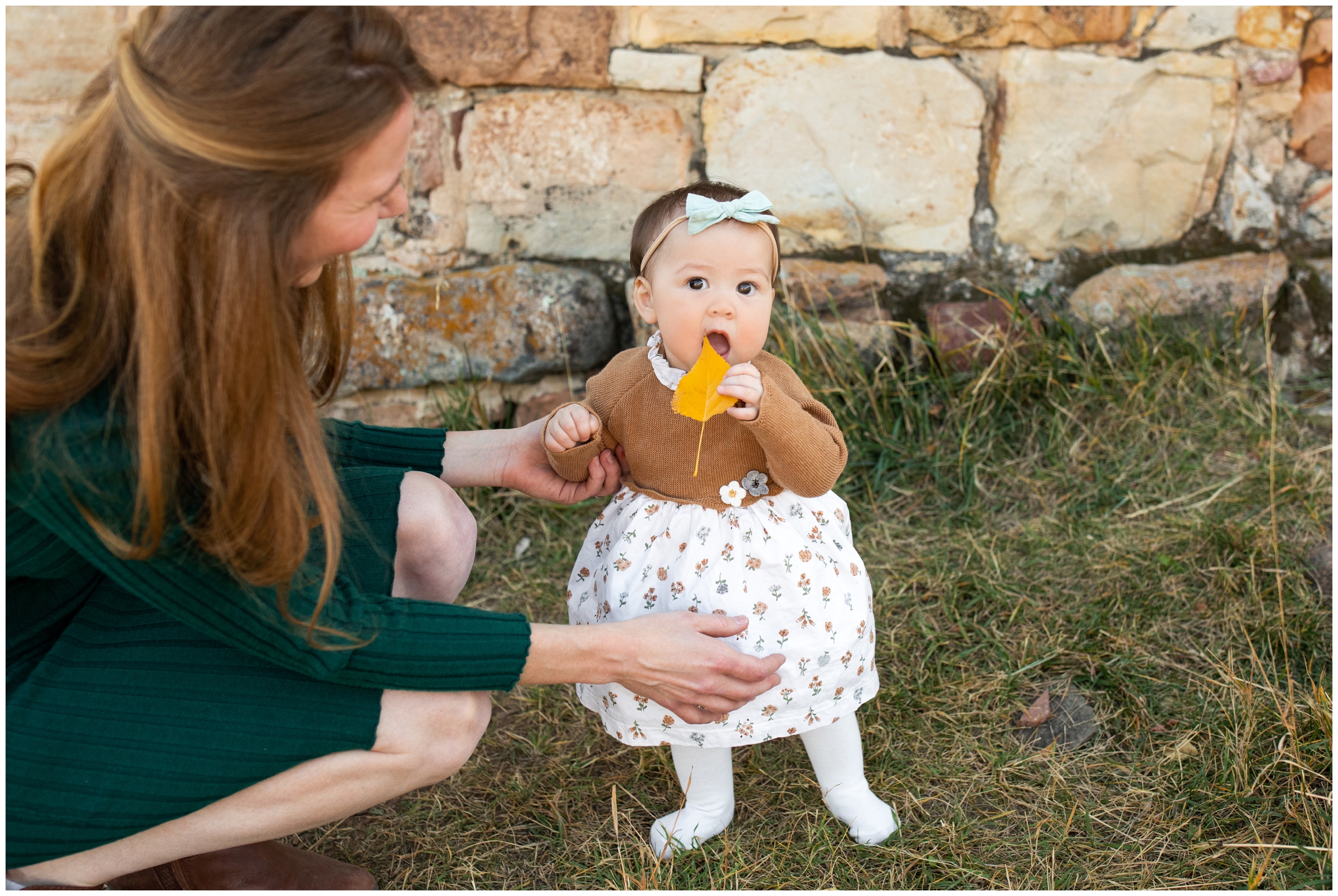 little girl chewing on leaf during candid Colorado family photos by Plum Pretty photography 