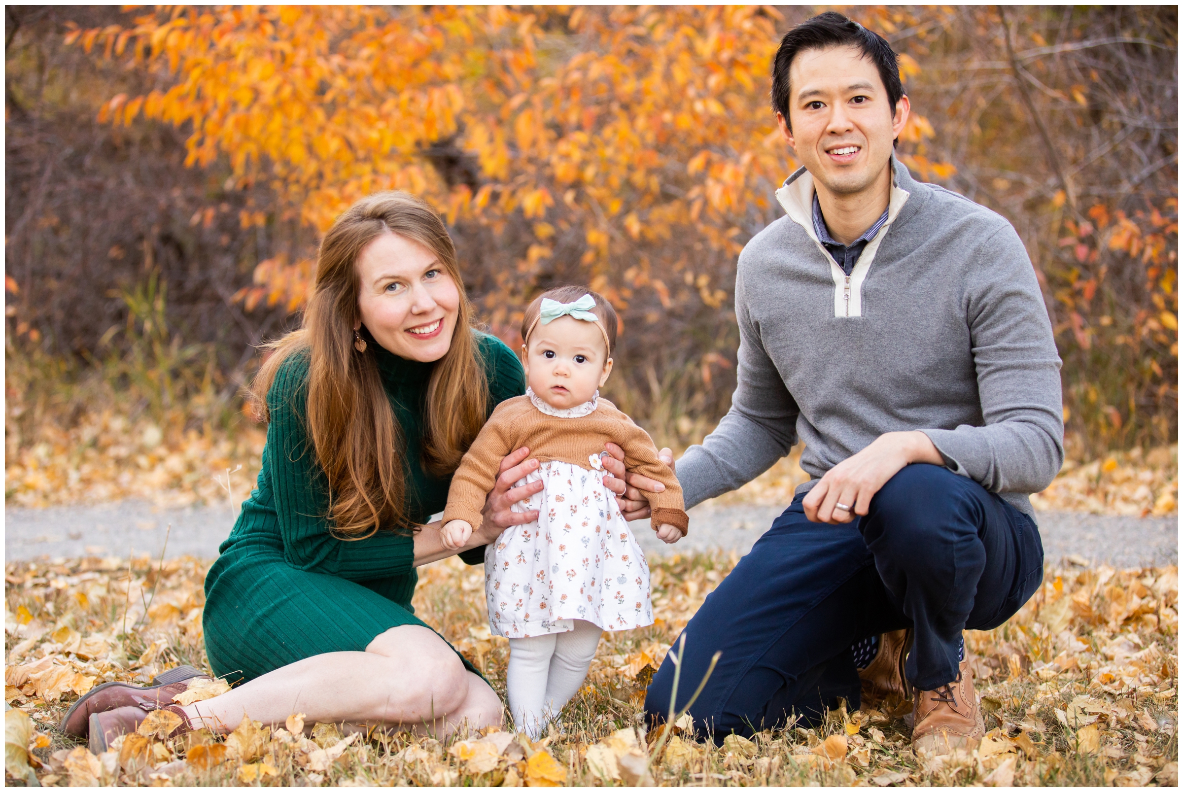 family sitting in crunchy leaves during Boulder fall family pictures at South Mesa Trail by Colorado portrait photographer Plum Pretty Photography