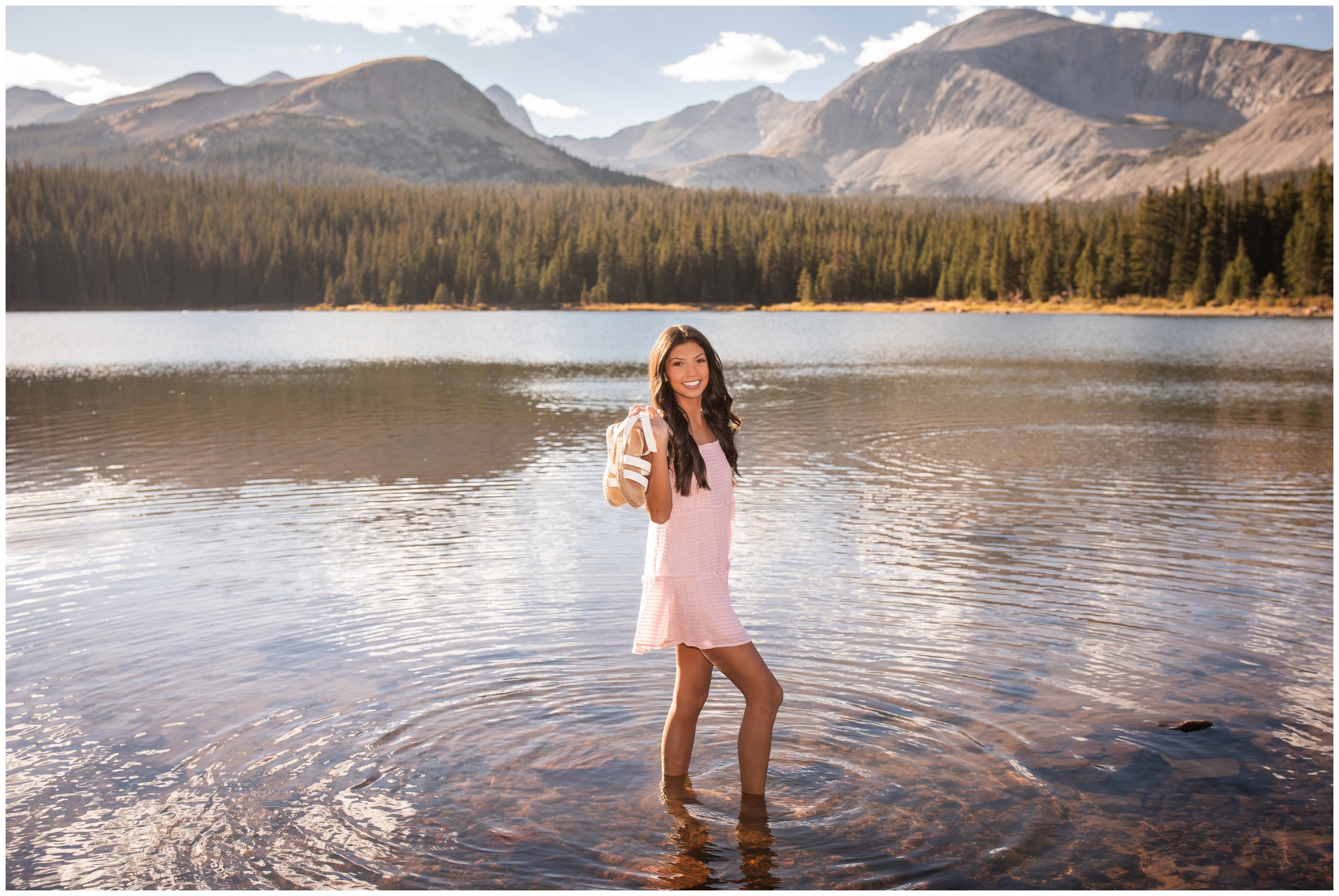teen girl posing in mountain lake during Colorado senior photography session at Brainard Lake 