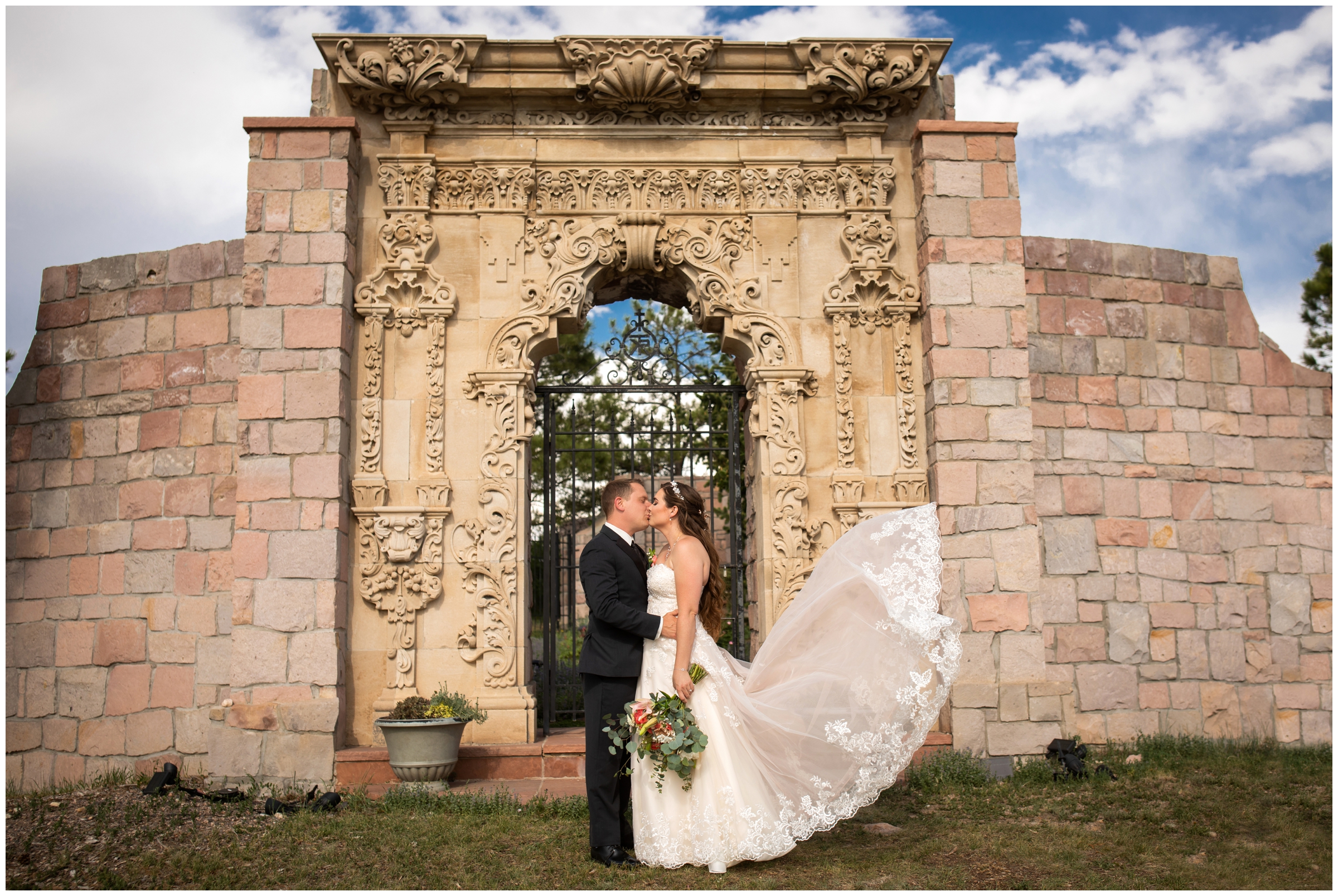 couple kissing in front of memorial gardens at Colorado castle wedding in Sedalia Colorado 