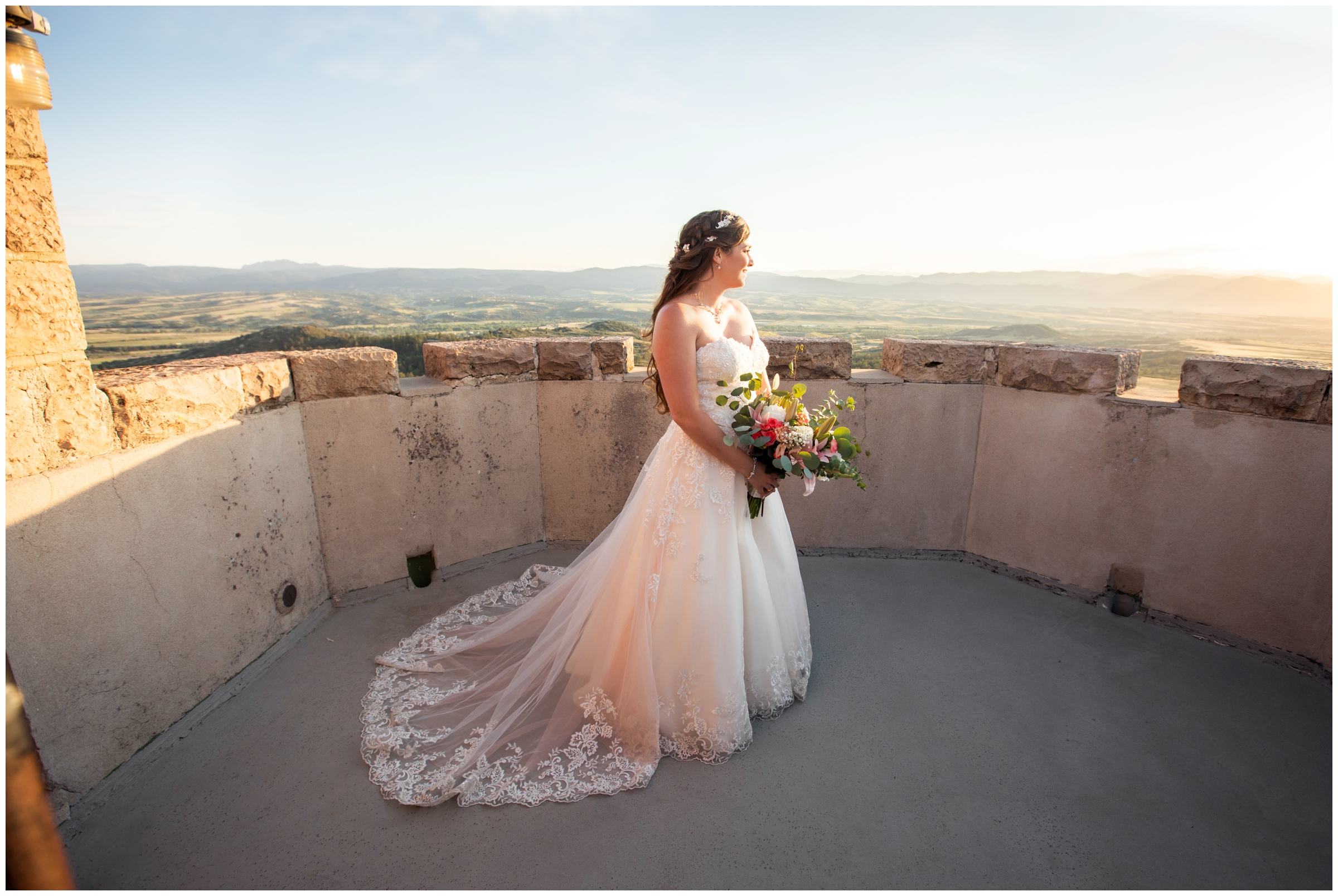 bride posing on top of castle with mountains in background at Cherokee Ranch summer wedding photos