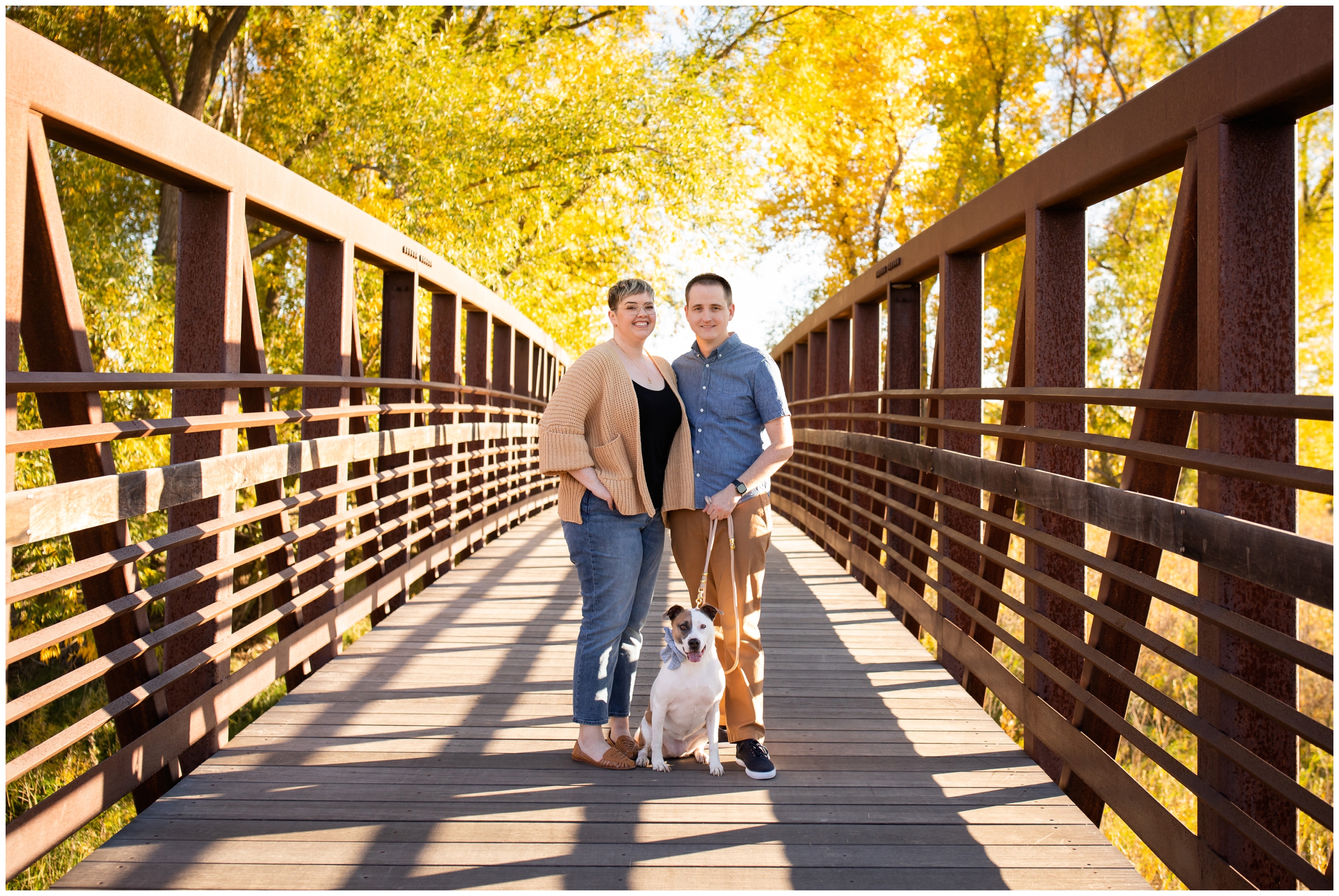 family posing on a bridge during Colorado couples photos with dog at Sandstone Ranch by Longmont portrait photographer Plum Pretty Photography