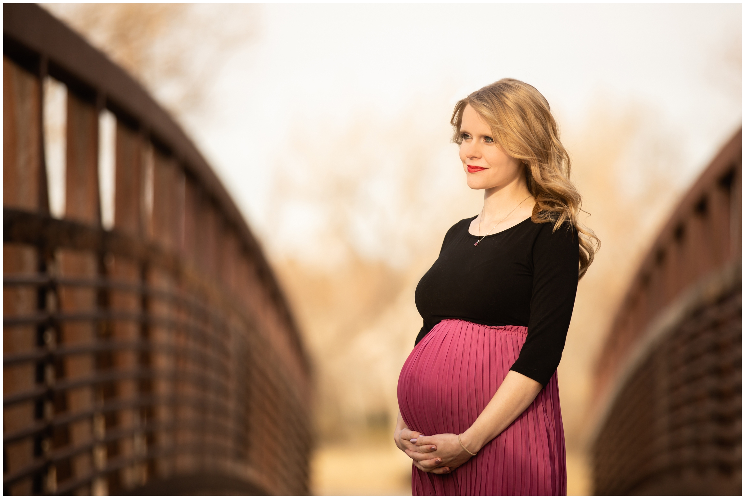 pregnant woman posing on bridge during Colorado fall maternity pictures in Centennial