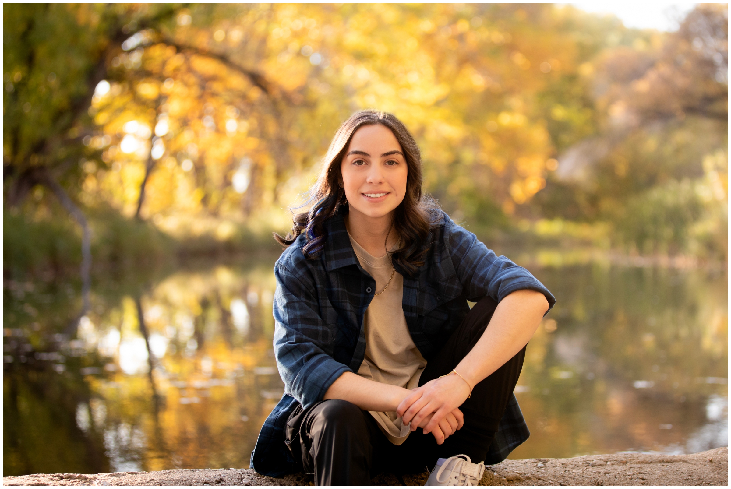 teen posing in front of fall foliage during Mead High School graduation photography session 