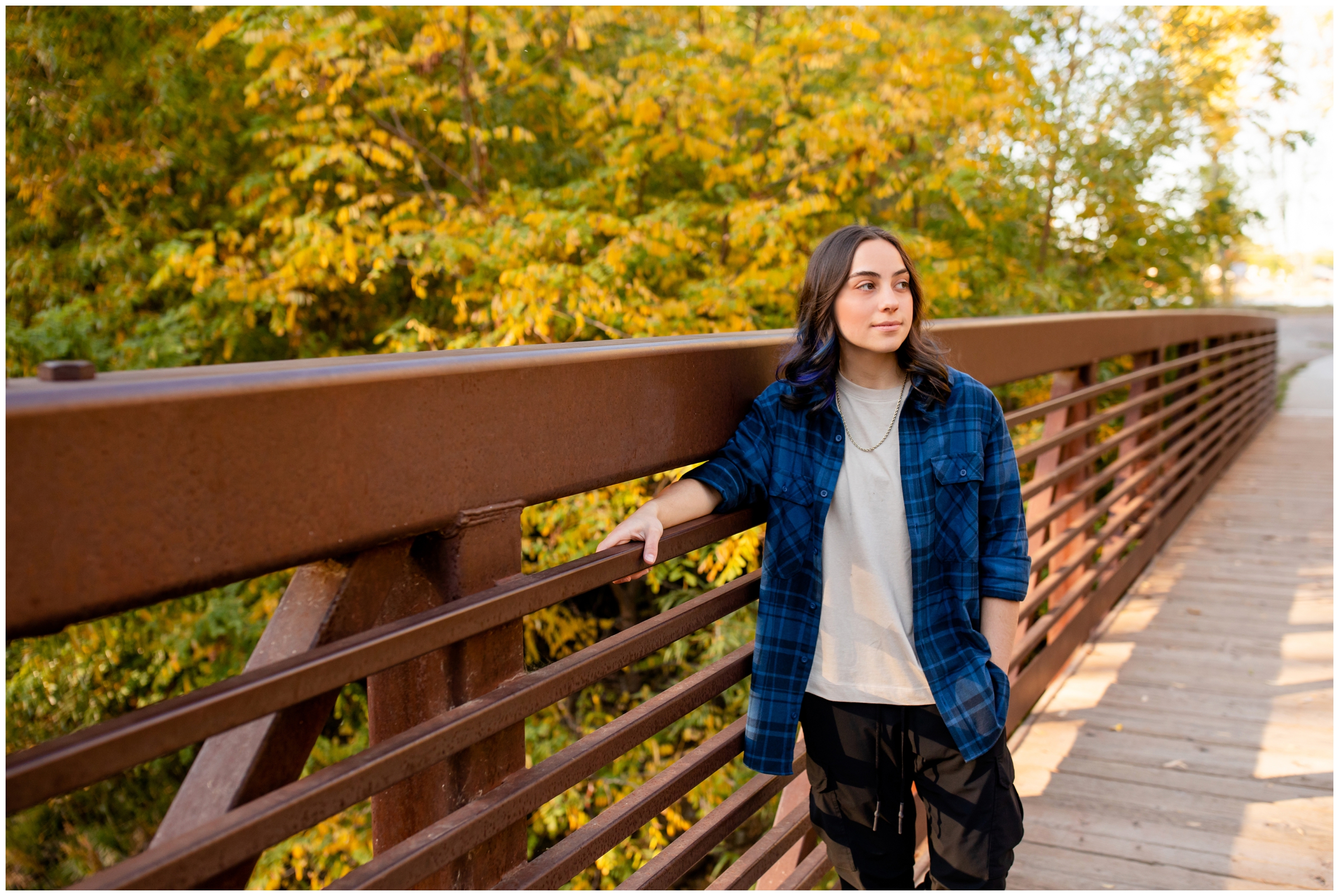 teen girl posing on bridge during fall senior portraits at Golden Ponds Longmont 