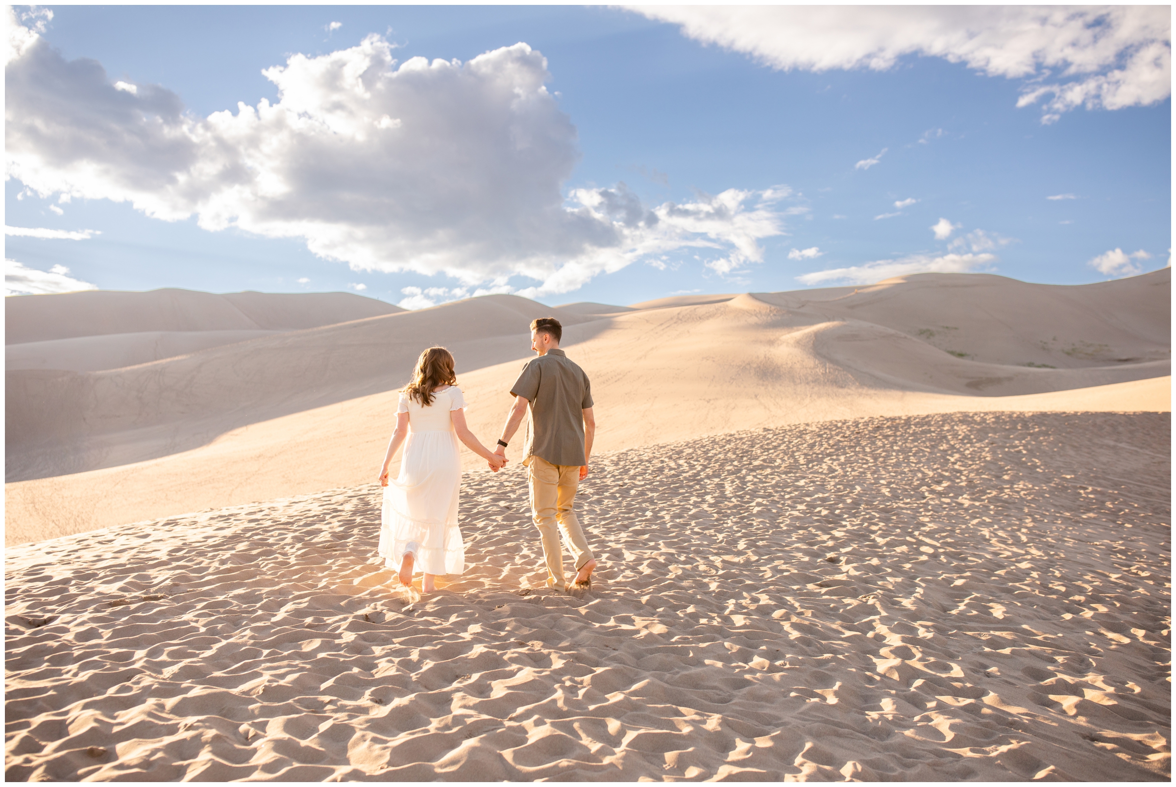 couple holding hands and walking during portraits at the Great Sand Dunes 