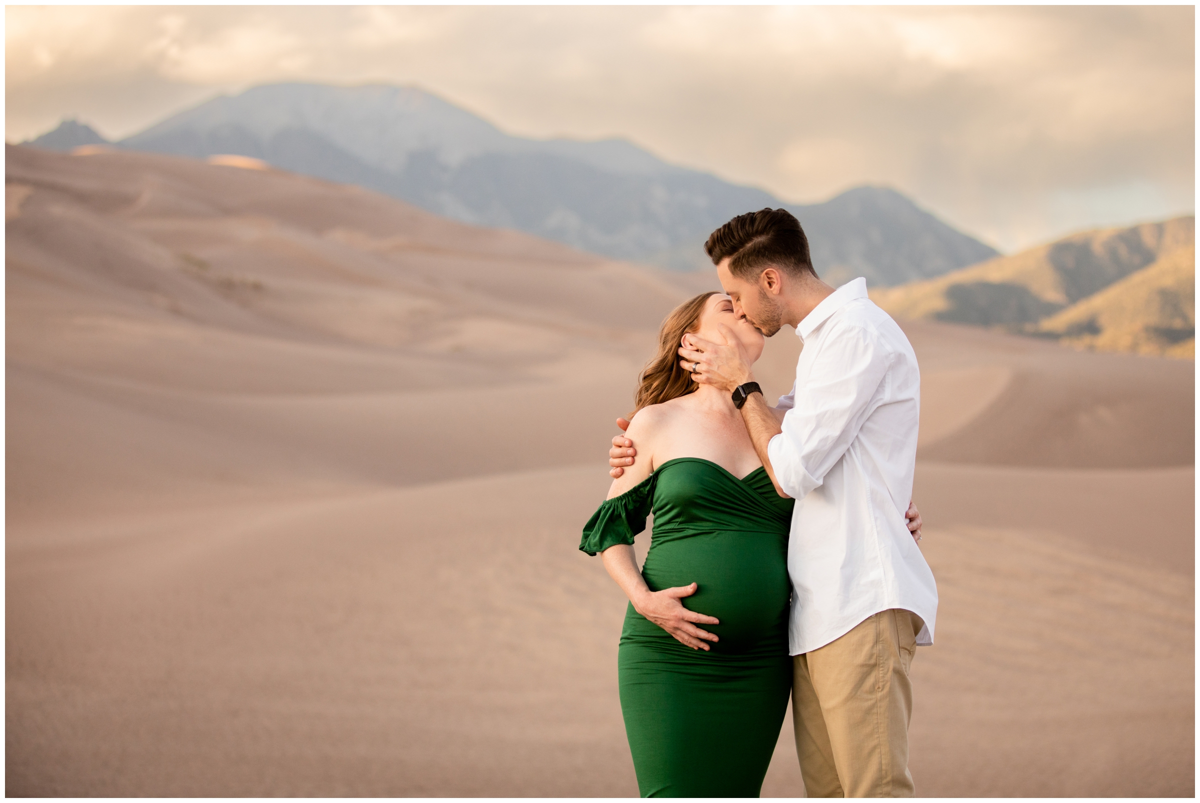 couple kissing at the Great Sand Dunes during Colorado summer maternity photography session 