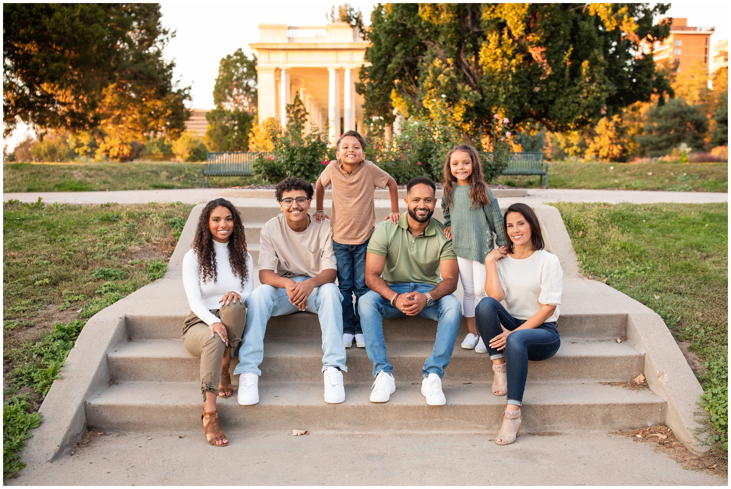 family posing on steps in front of Cheesman Park Pavilion during fall family portraits in Denver 