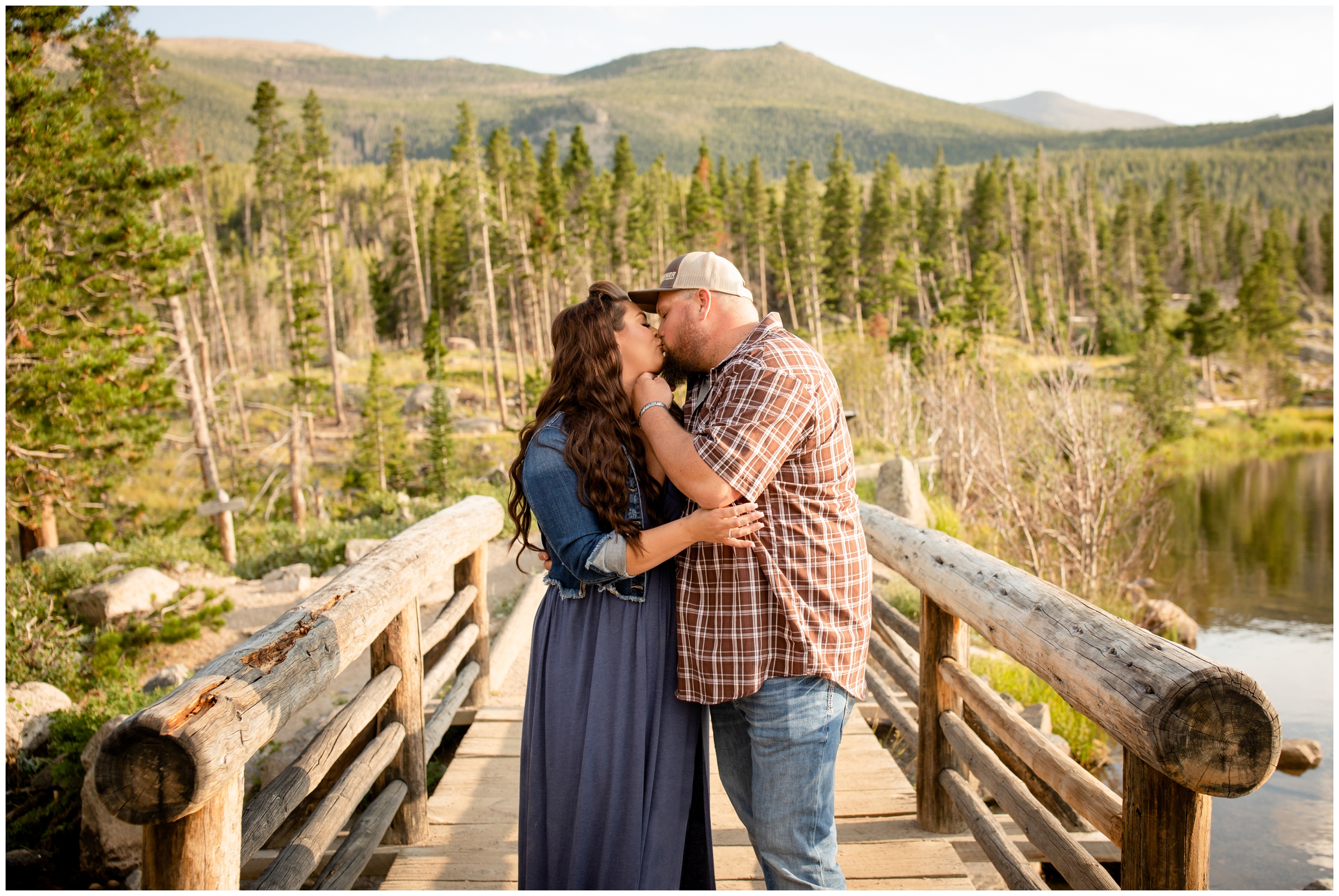 couple kissing on wooden bridge during Estes Park Colorado maternity pictures at Sprague Lake 