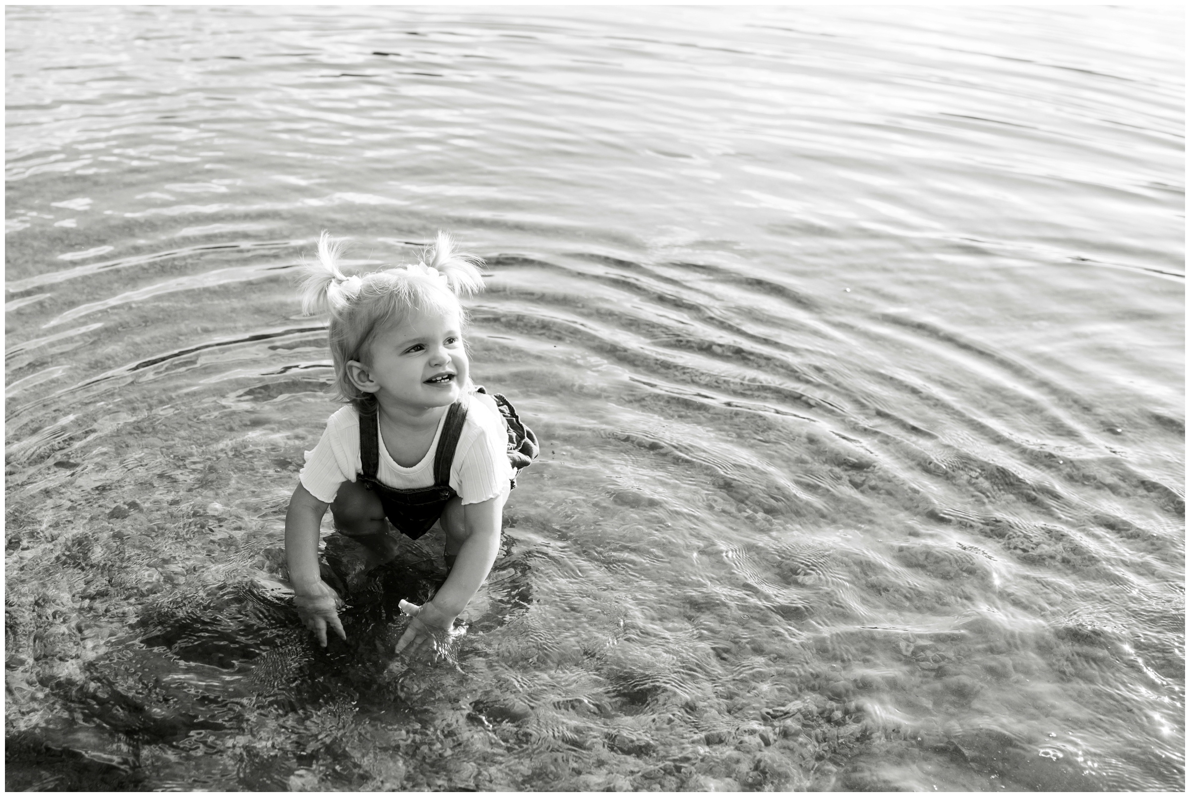 little girl splashing in a lake during Estes Park family photography session at Sprague Lake