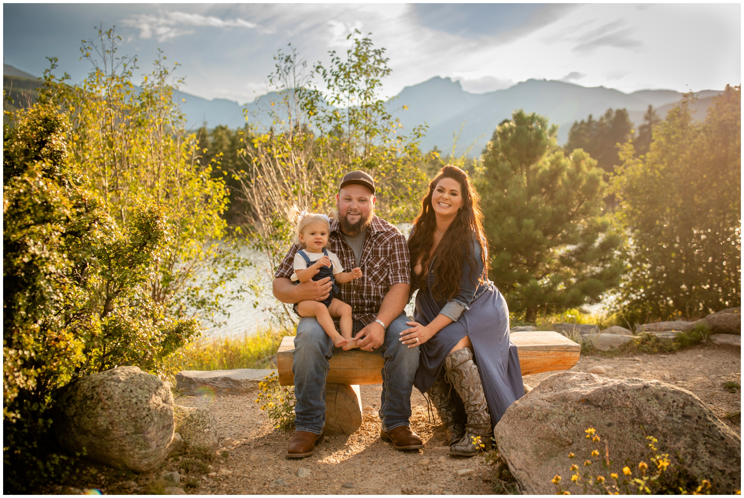 family sitting on wooden bench at Sprague Lake during Rocky Mountain National Park family pictures 