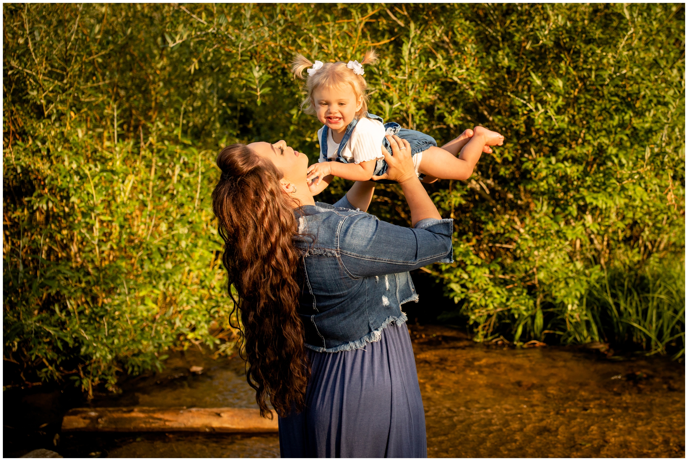 mom lifting daughter in the air during candid family pictures in Estes Park 
