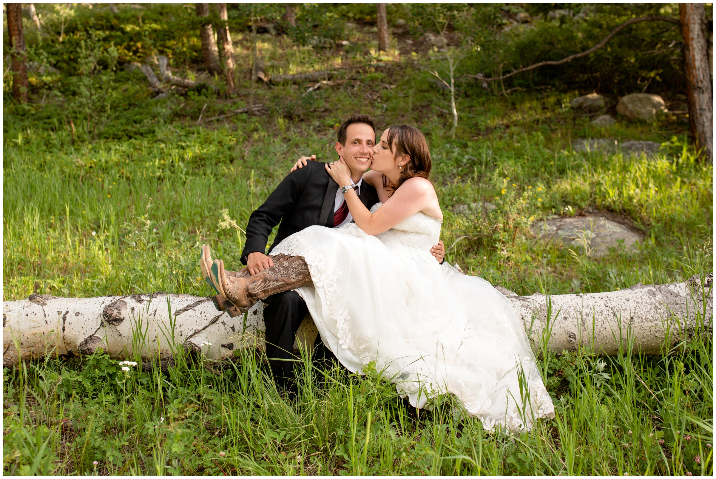 bride and groom kissing on downed tree during Estes Park elopement photos 