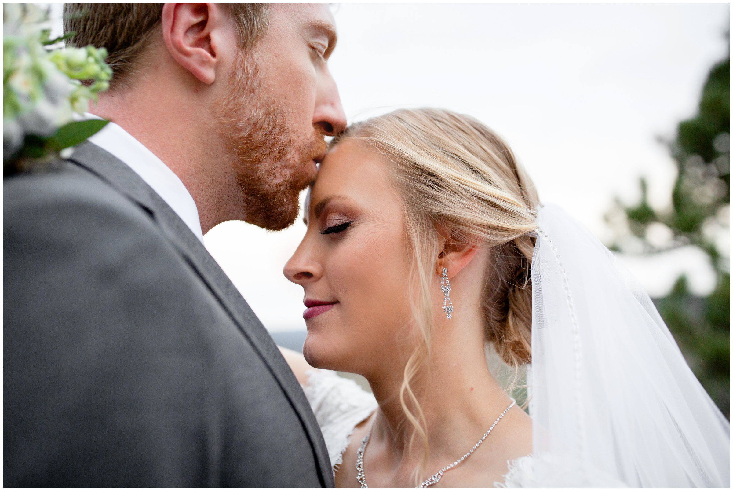 groom kissing bride's forehead during wedding at Lionscrest Manor by Lyons Colorado photographer Plum Pretty Photography