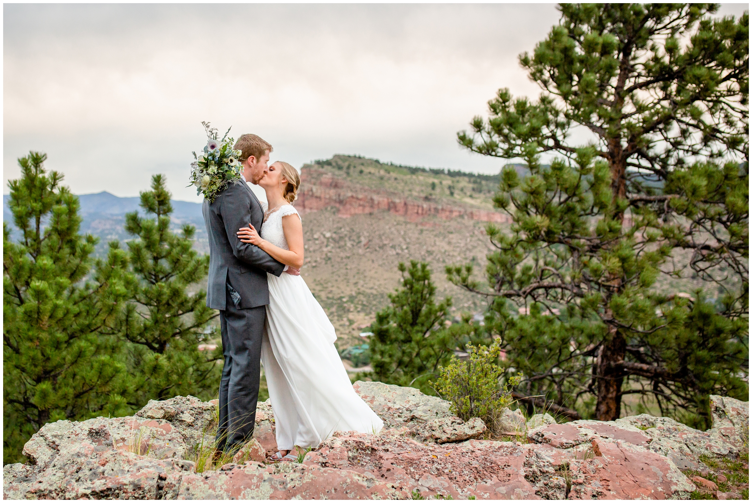 couple kissing on the edge of cliff during mountain wedding portraits at Lionscrest Manor