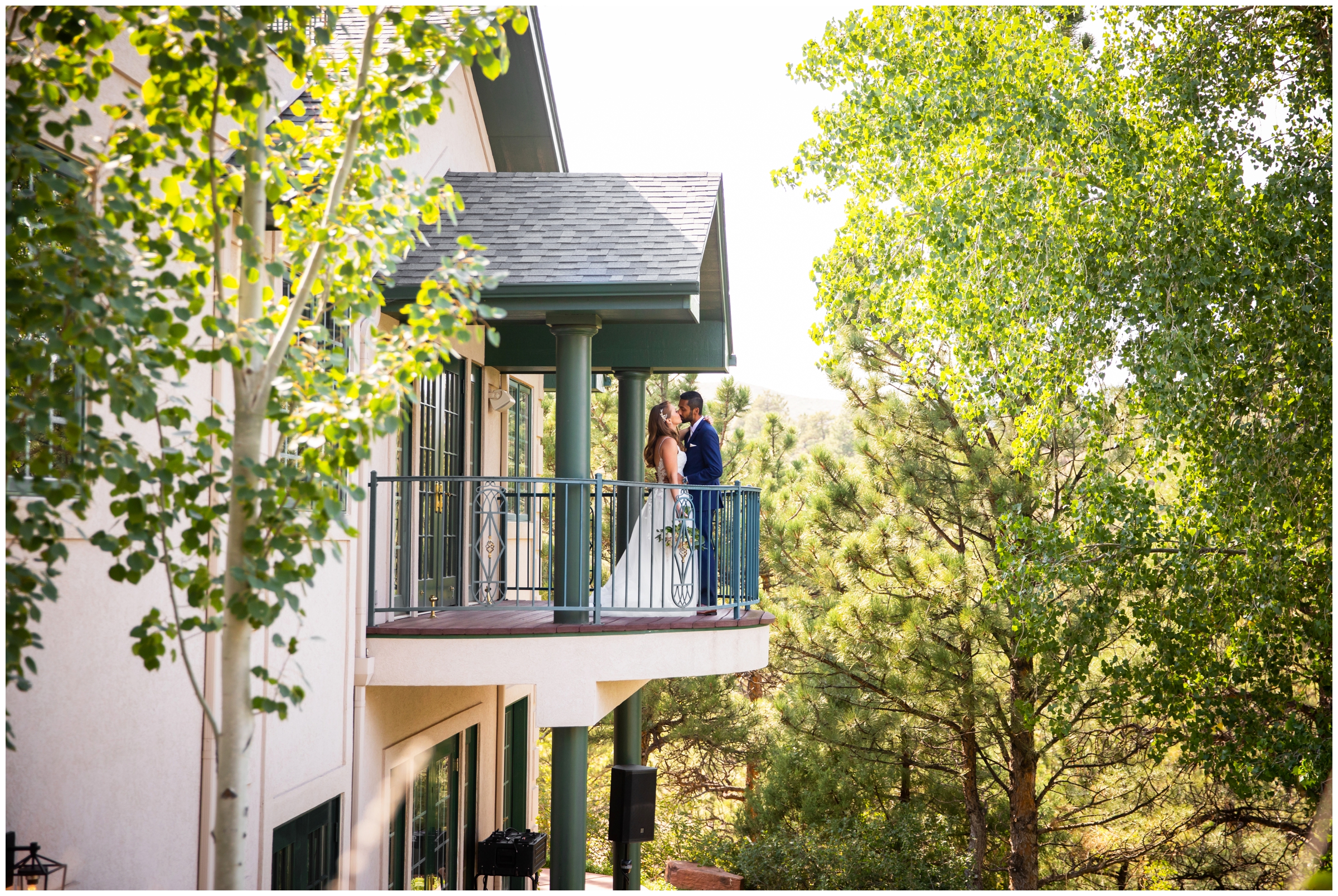 couple kissing on balcony during summer wedding portraits at Lionscrest Manor