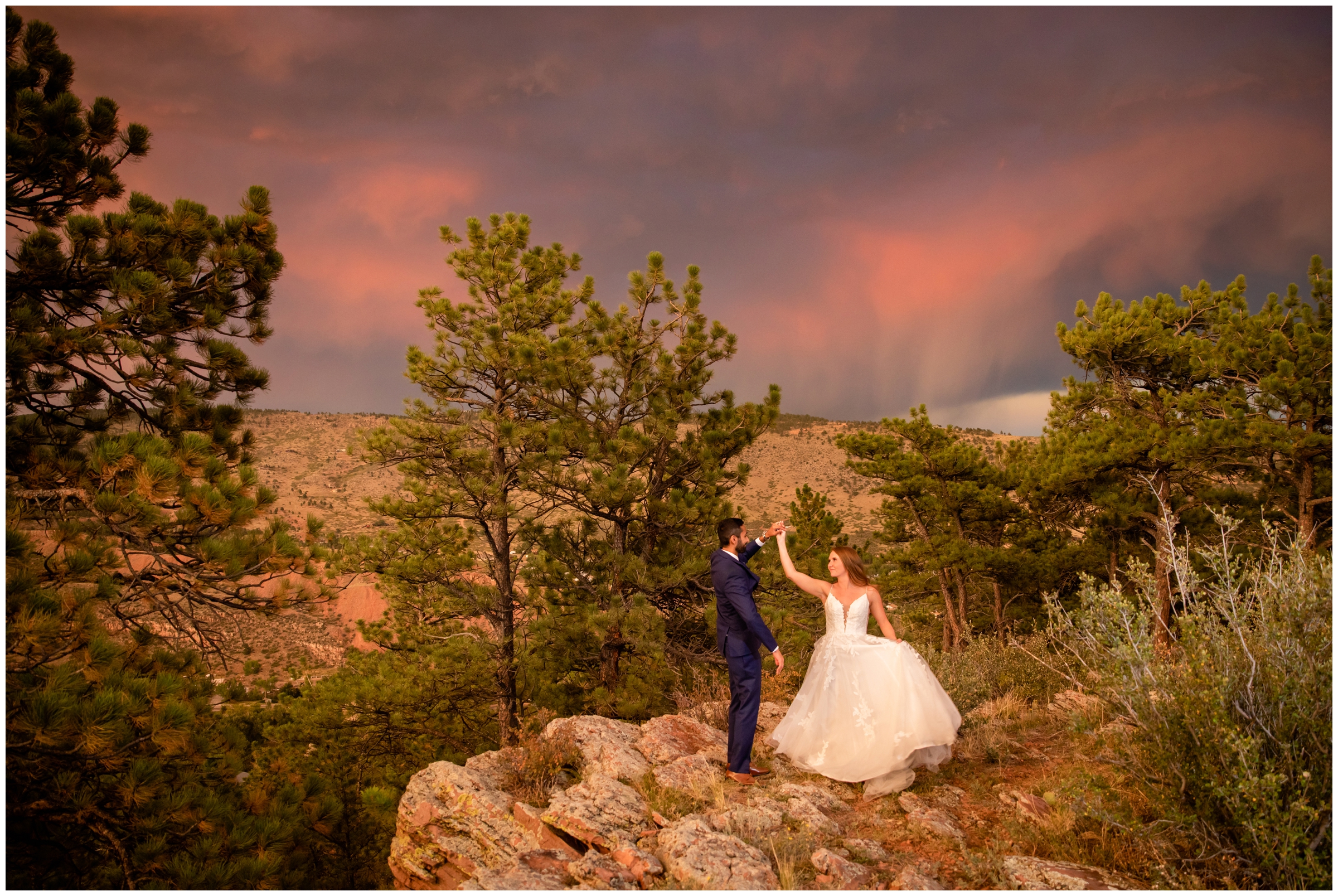 couple dancing on edge of mountain under a colorful sunset sky at Lionscrest Manor Colorado wedding