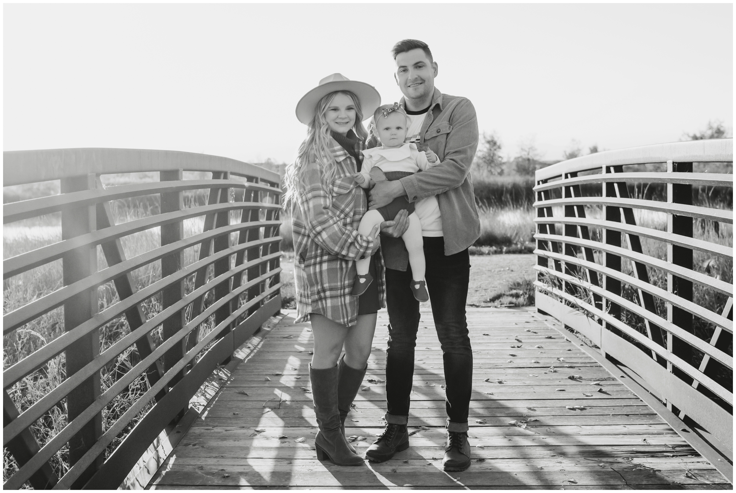 family posing on bridge during Longmont Colorado photography session by Plum Pretty Photos