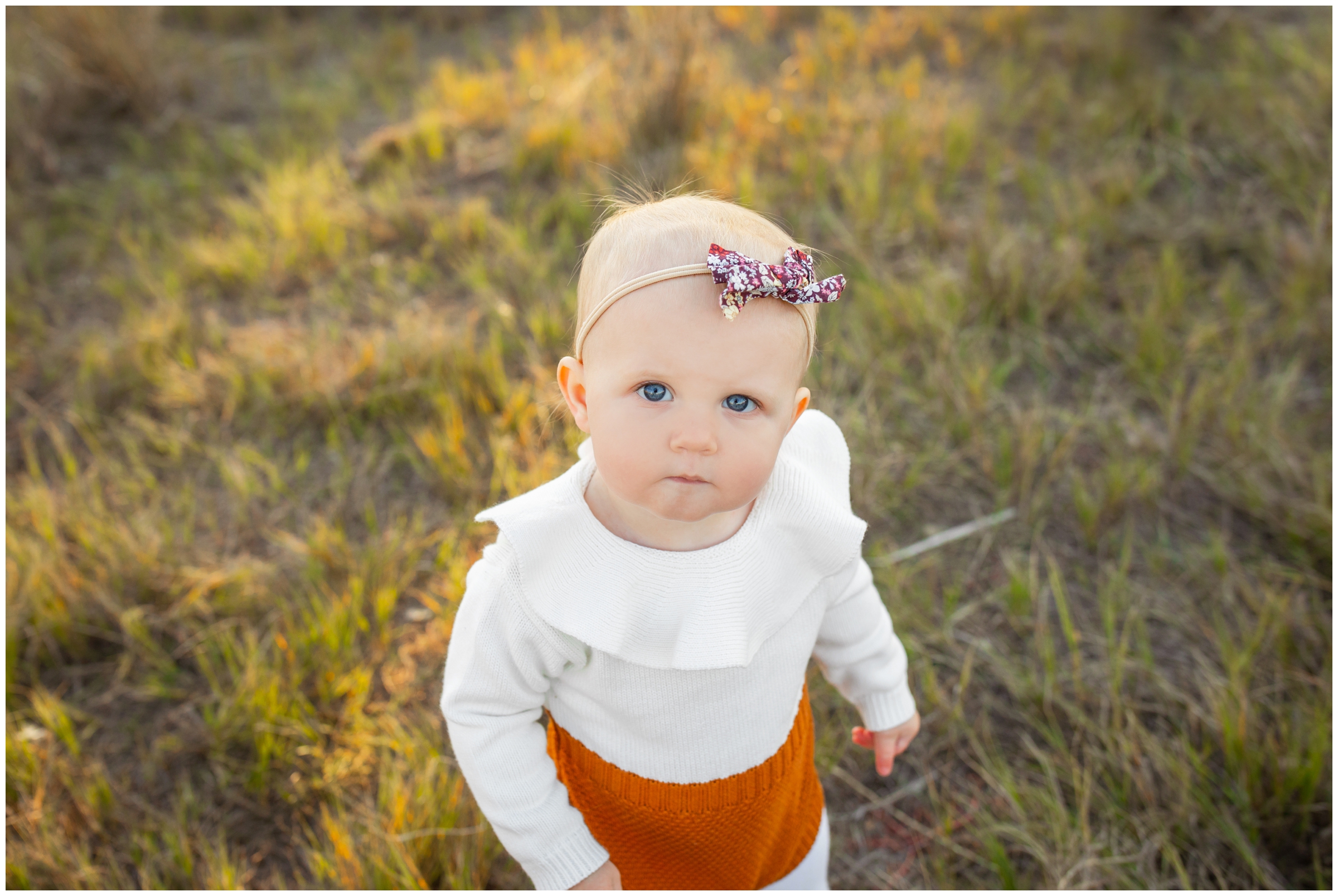 baby girl with bow headband posing for fall family photography session in Longmont Colorado 