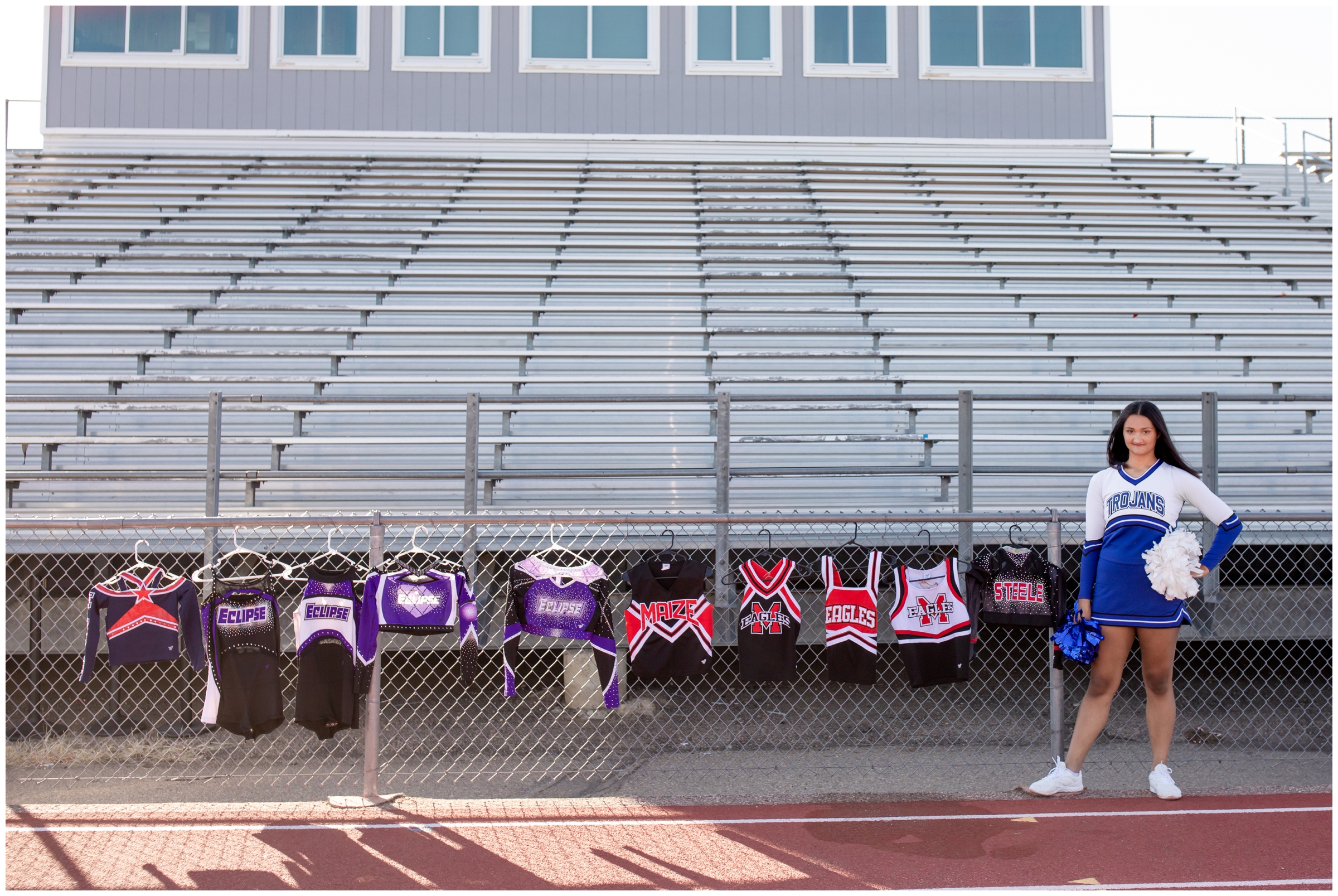 teen girl posing with all her cheerleader uniforms during senior photography session in Colorado 