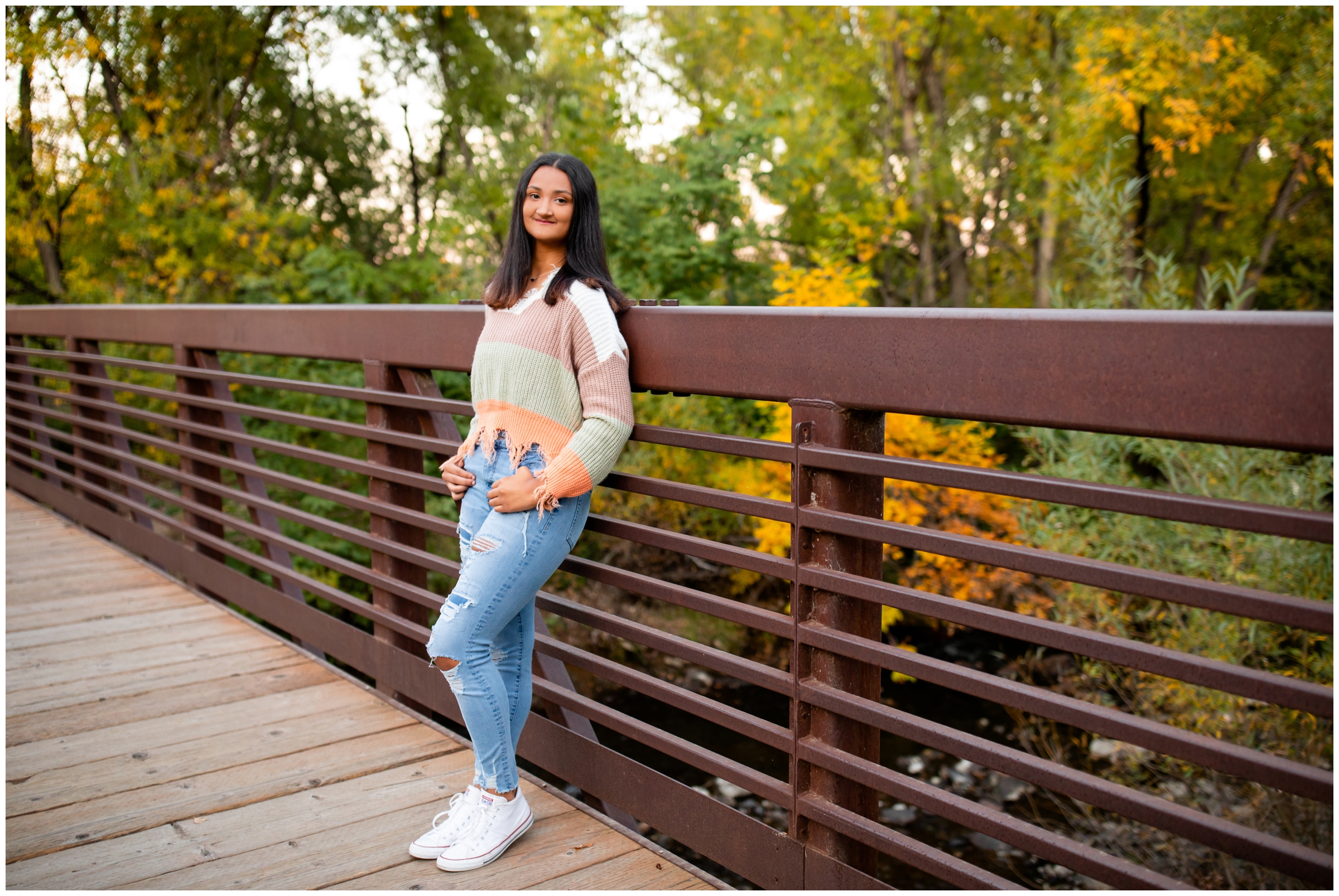 teen leaning on bridge at Golden Ponds during Colorado graduation photo session 