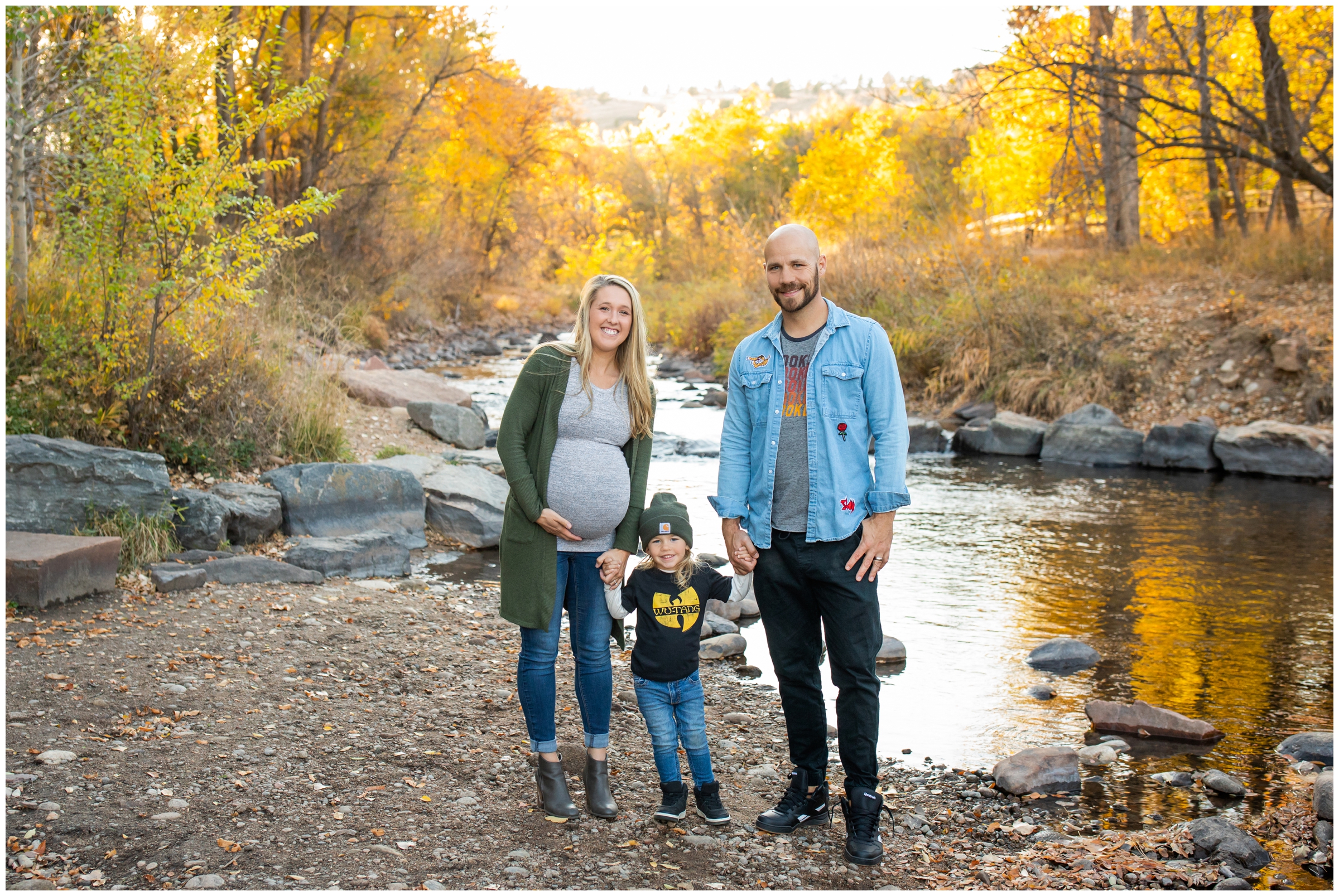 family posing next to the river with fall foliage in background at Lyons Colorado family portraits at bohn Park 