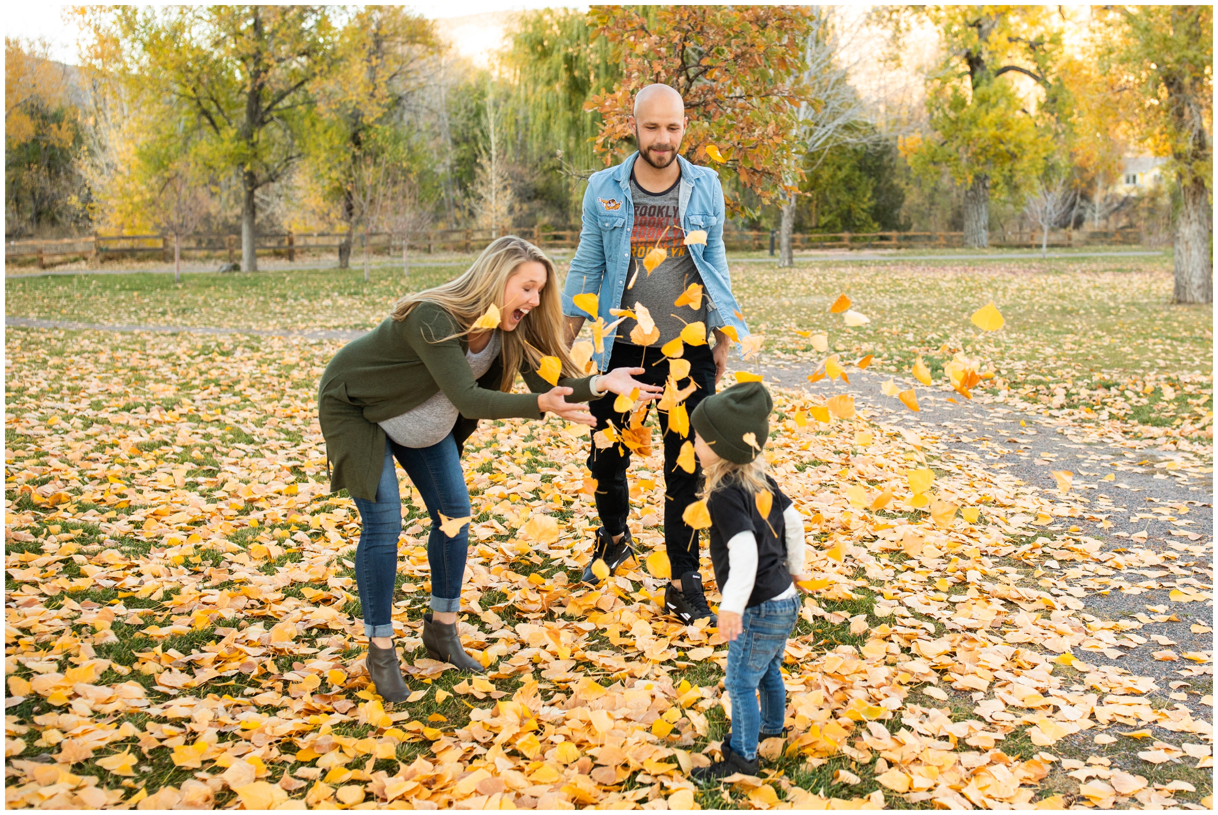 family throwing leaves in the air during candid family photos at Bohn Park in Colorado 